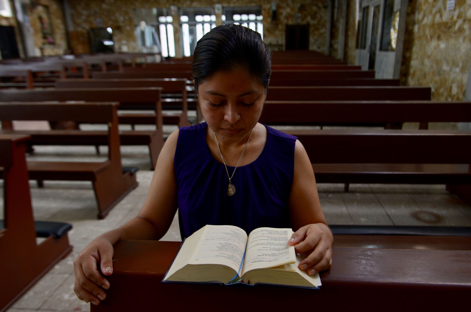 Imagen de una feligresa leyendo la biblia en la iglesia San Juan Bosco, durante la misa virtual del párroco Edilberto Torres, en el centro sur de Guayaquil (Ecuador). Foto: EFE