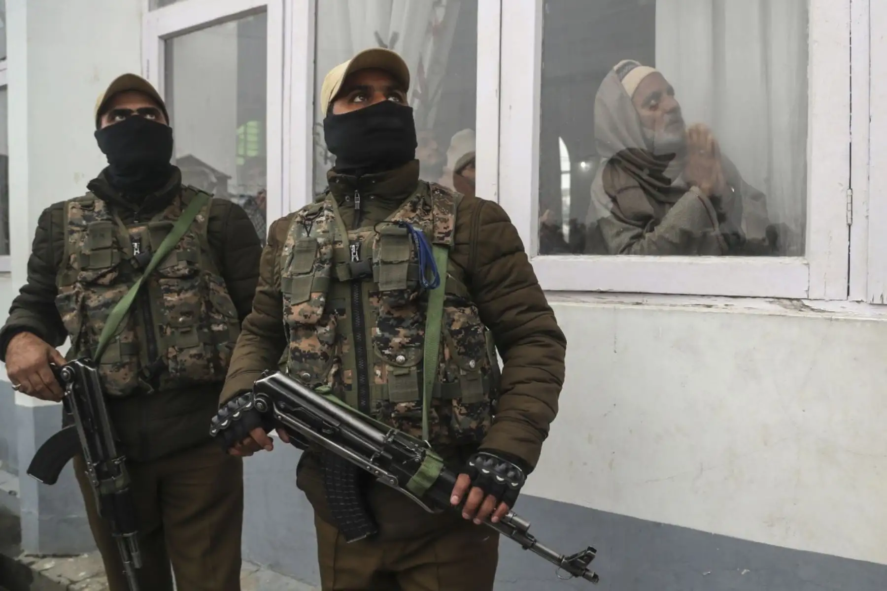 Policías indios vigilan mientras los musulmanes de Kashmiri rezan mientras el sacerdote principal, invisible, muestra una reliquia del profeta Mahoma del Islam en el santuario de Hazratbal, con motivo del aniversario del nacimiento del profeta en Srinagar, India. Foto: AP/Pulitzer