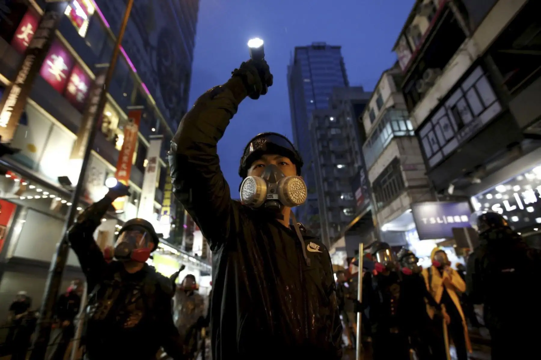 Los manifestantes que protestan contra el proyecto de ley de extradición apuntan sus linternas hacia la policía antidisturbios mientras son perseguidos por las calles de Hong Kong, China. Foto: Reuters/Pulitzer