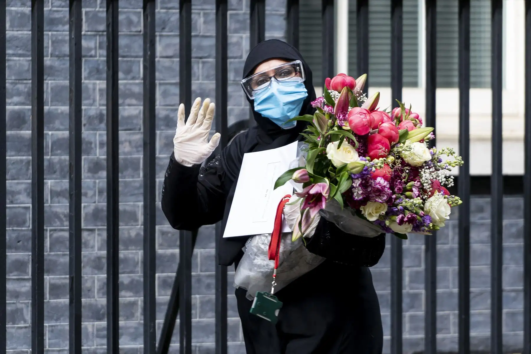 Una mujer llega para entregar un segundo ramo de flores a un funcionario de la residencia del primer ministro británico, en el centro de Londres. Foto: AFP