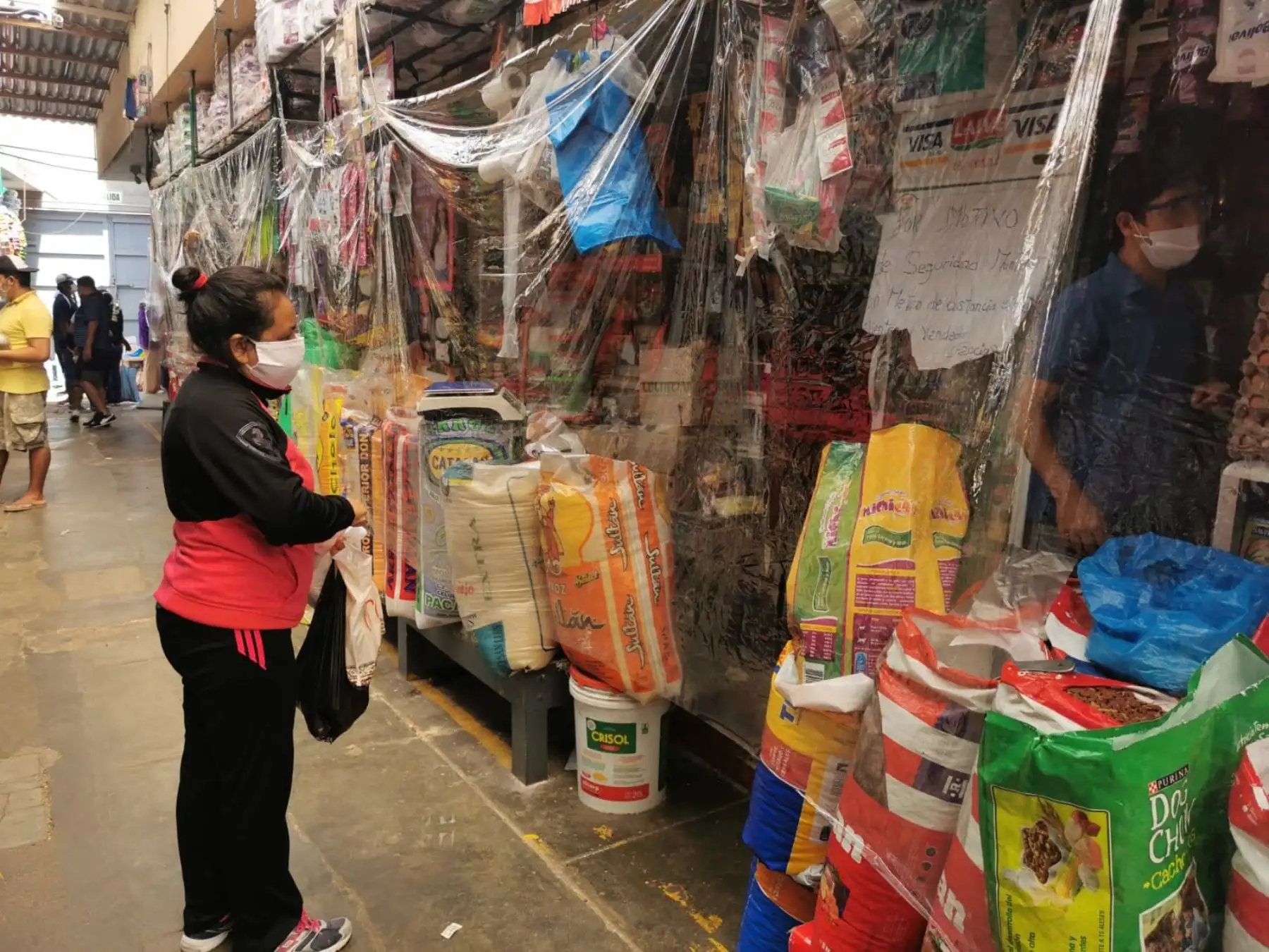 Comerciantes del mercado del distrito de Víctor Larco, en Trujillo, evitan el contagio de coronavirus (covid-19) con protectores de plástico. ANDINA/Difusión