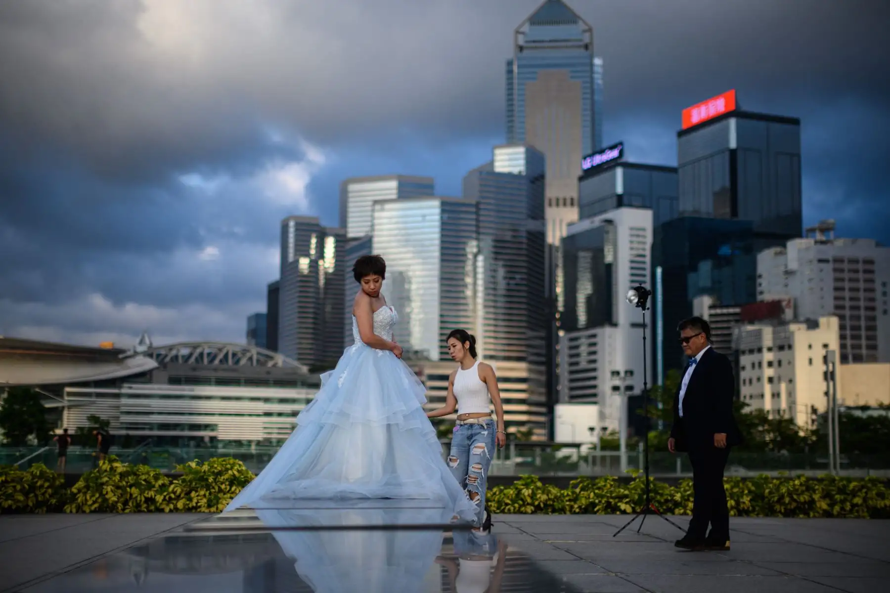 Una pareja se prepara para posar para las fotos de su boda en el parque Tamar en Hong Kong. El gobierno anunció planes para aliviar las principales medidas de distanciamiento social, incluida la reapertura de escuelas, cines, bares y salones de belleza después de que el territorio chino detuvo en gran medida la transmisión local del coronavirus mortal. Foto: AFP