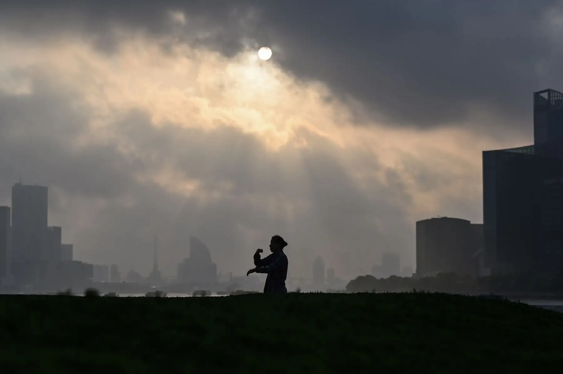 Una mujer hace ejercicio durante el amanecer en el paseo marítimo del Bund a lo largo del río Huangpu en Shanghai. Foto: AFP