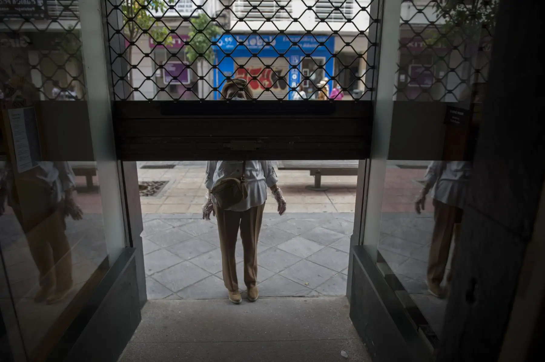 Un cliente se encuentra en la puerta de la librería Palas, mientras la tienda se prepara para la reapertura en Sevilla. Foto: AFP