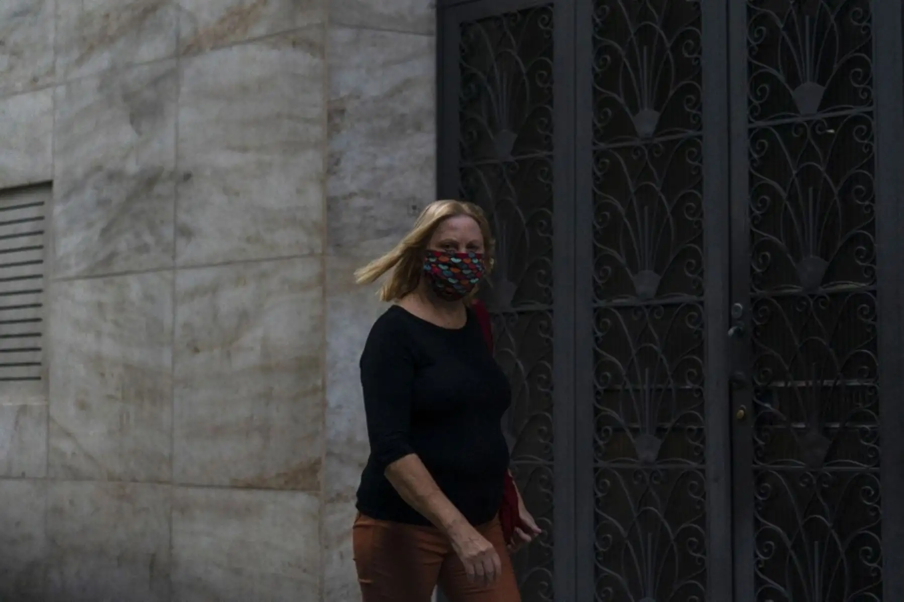Una mujer con una máscara facial camina por las calles de Río de Janeiro, en Brasil. Foto: AFP