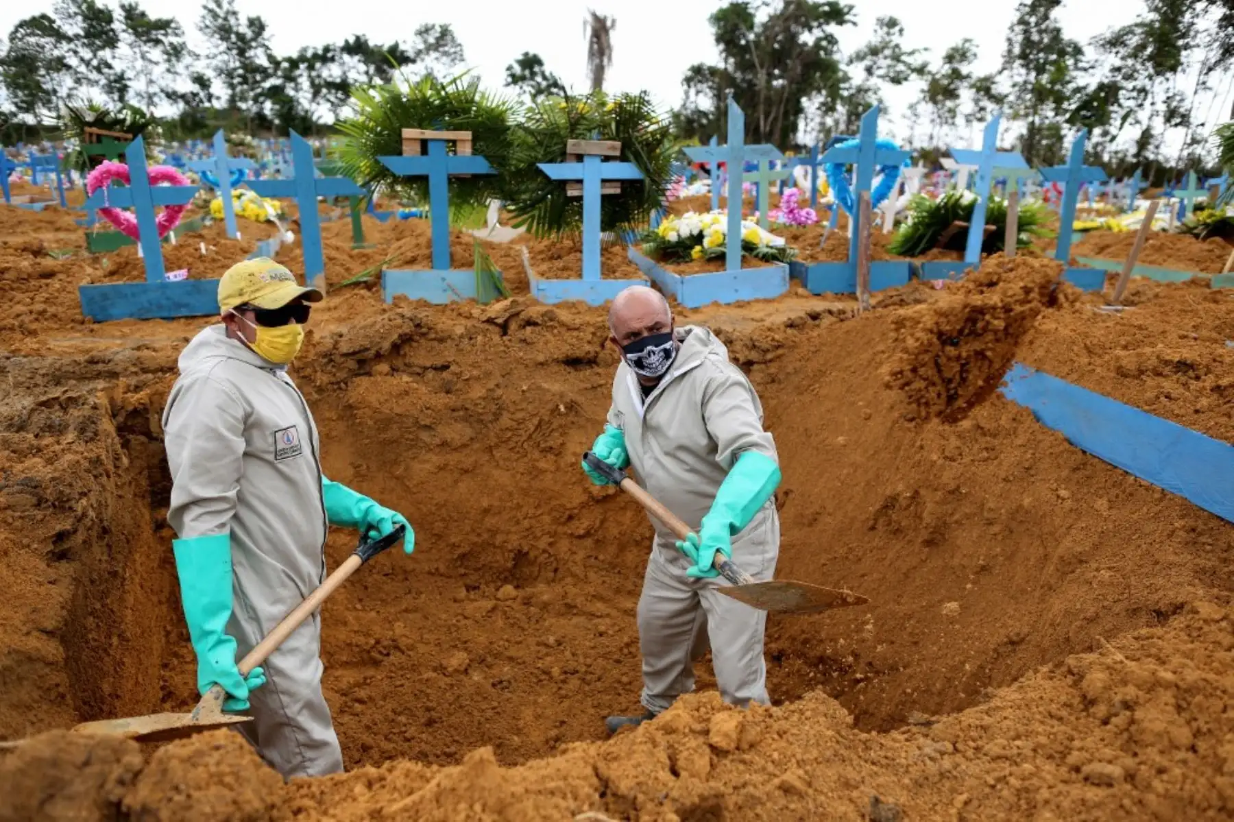 El brasileño Ulisses Xavier, de 52 años, que ha trabajado durante 16 años en el cementerio Nossa Senhora en Manaos,, cava una tumba junto a un compañero. Foto: AFP