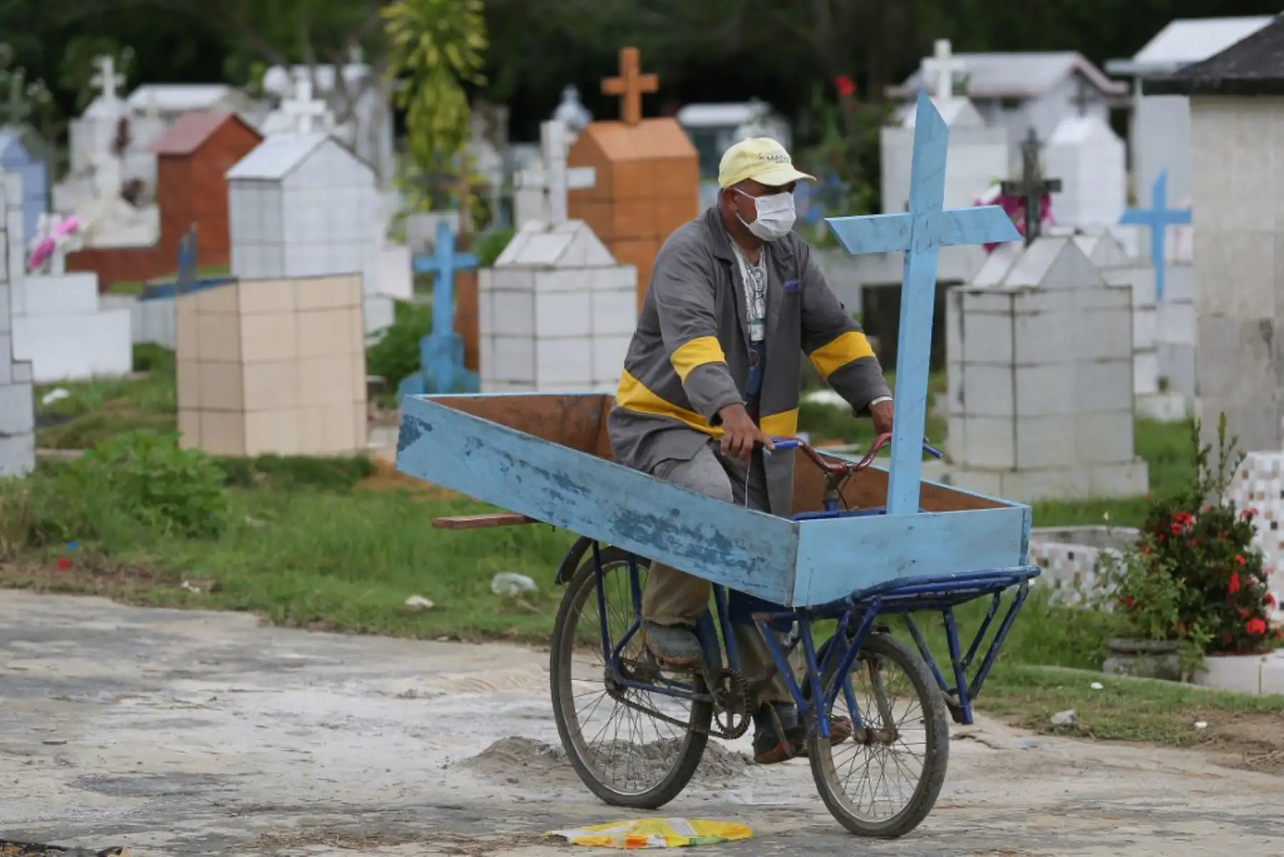 Ulises monta su bicicleta para llegara a cumplir su turno de trabajo en el cementerio Nossa Senhora, en Manaos. Foto: AFP