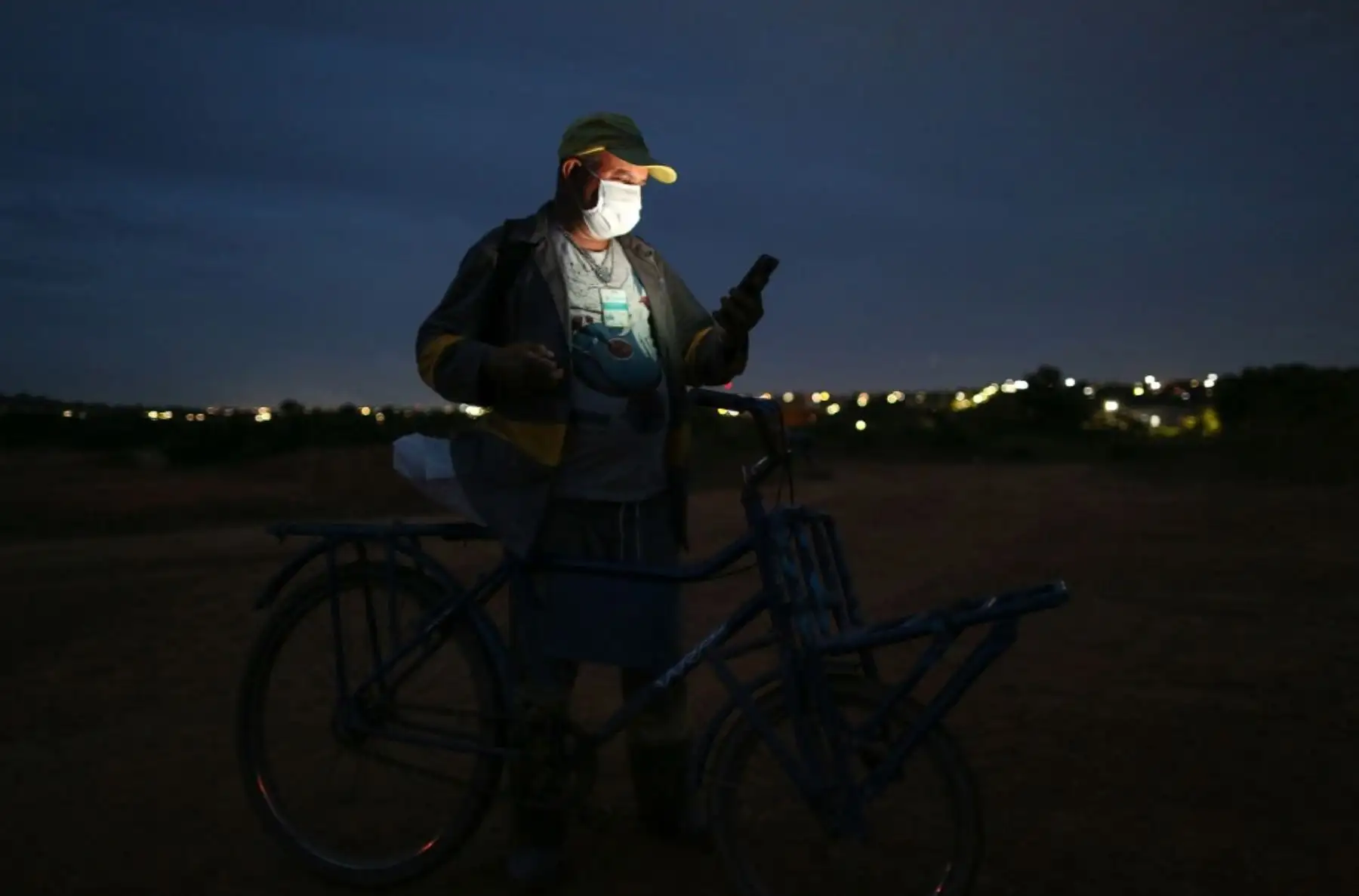 Ulises observa su celular antes de retornar a casa en bicicleta. Foto: AFP