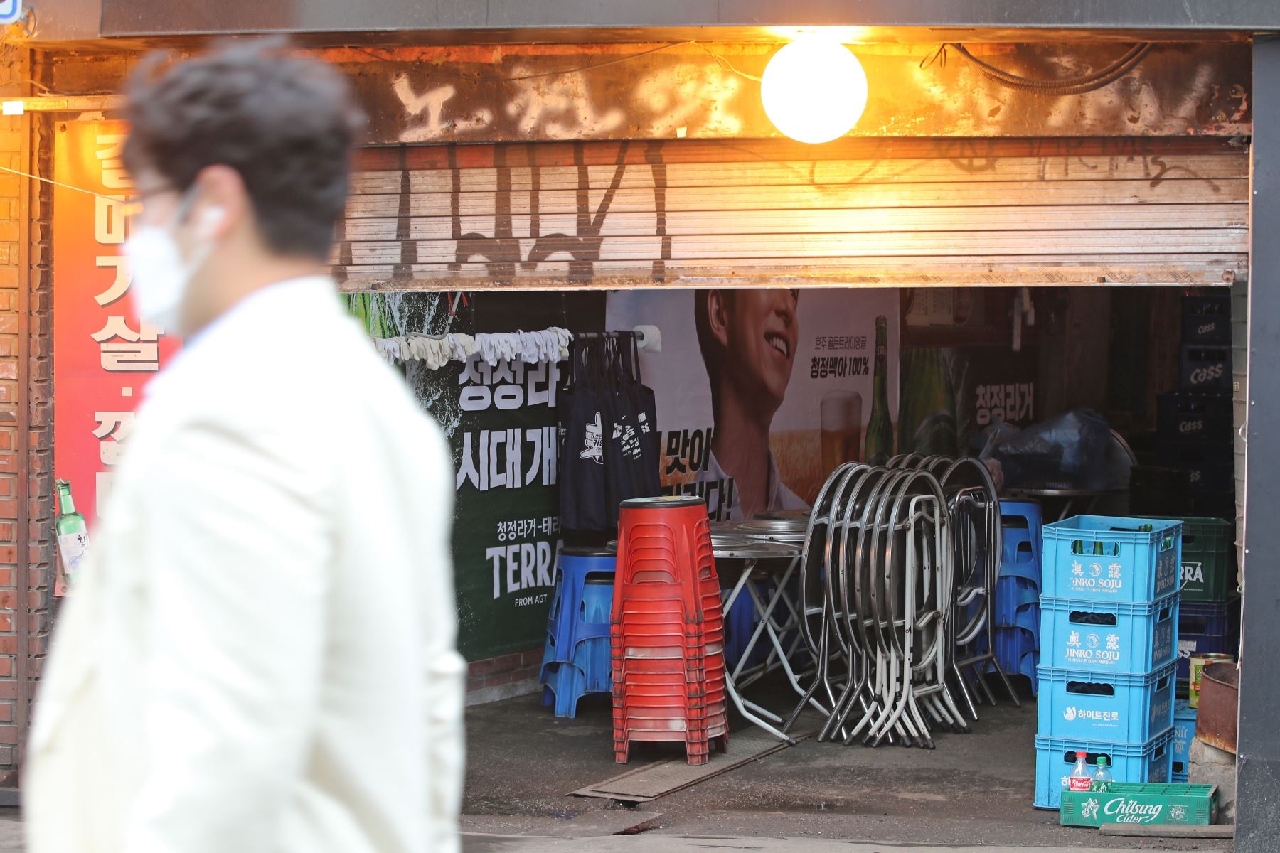Un hombre pasa por delante de un bar en Sinchon, Seúl, Corea del Sur. Foto: EFE