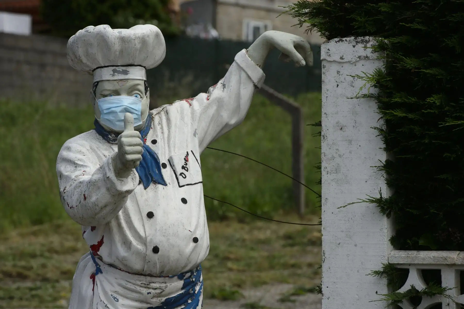 Una estatua de un cocinero con una máscara facial se muestra afuera de un restaurante en Vigo. Foto: AFP
