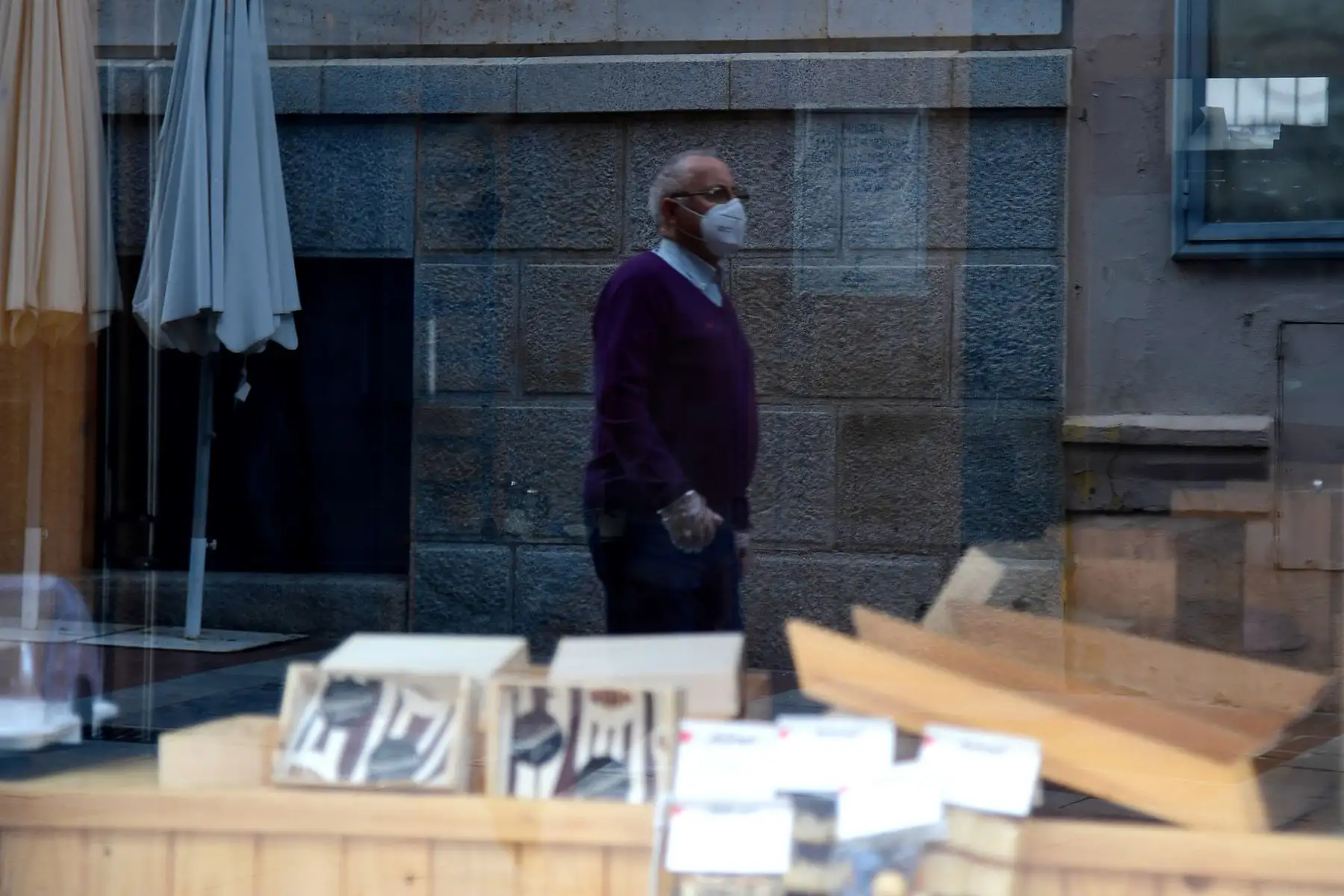 Un hombre con una máscara facial camina en una calle peatonal en Guadalajara en Castilla La Mancha. Foto: AFP