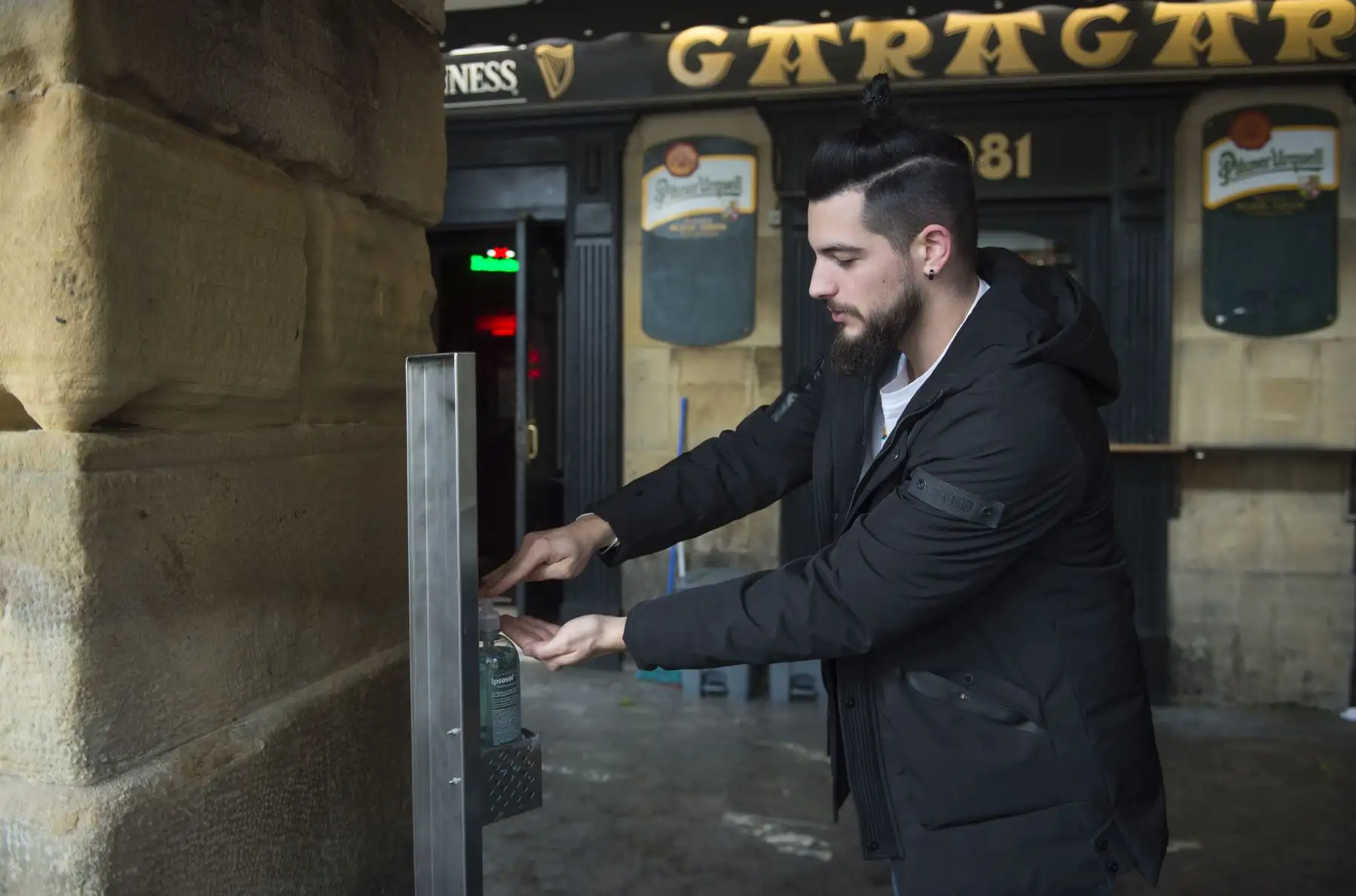 Un hombre usa gel desinfectante para lavarse las manos antes de sentarse en el bar con terraza en la ciudad vasca española de San Sebastián. Foto: AFP