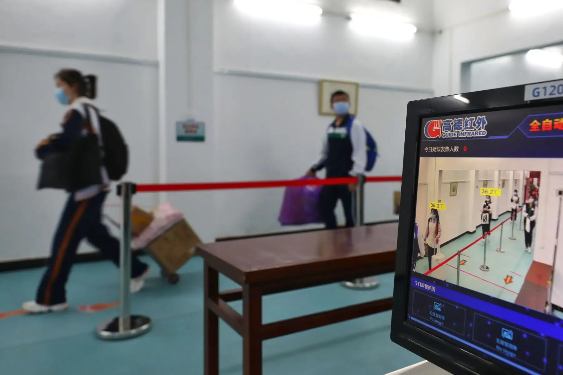 Los estudiantes pasan frente a una cámara de monitoreo de temperatura cuando ingresan a una escuela secundaria en Wuhan, en la provincia central china de Hubei. Foto: AFP