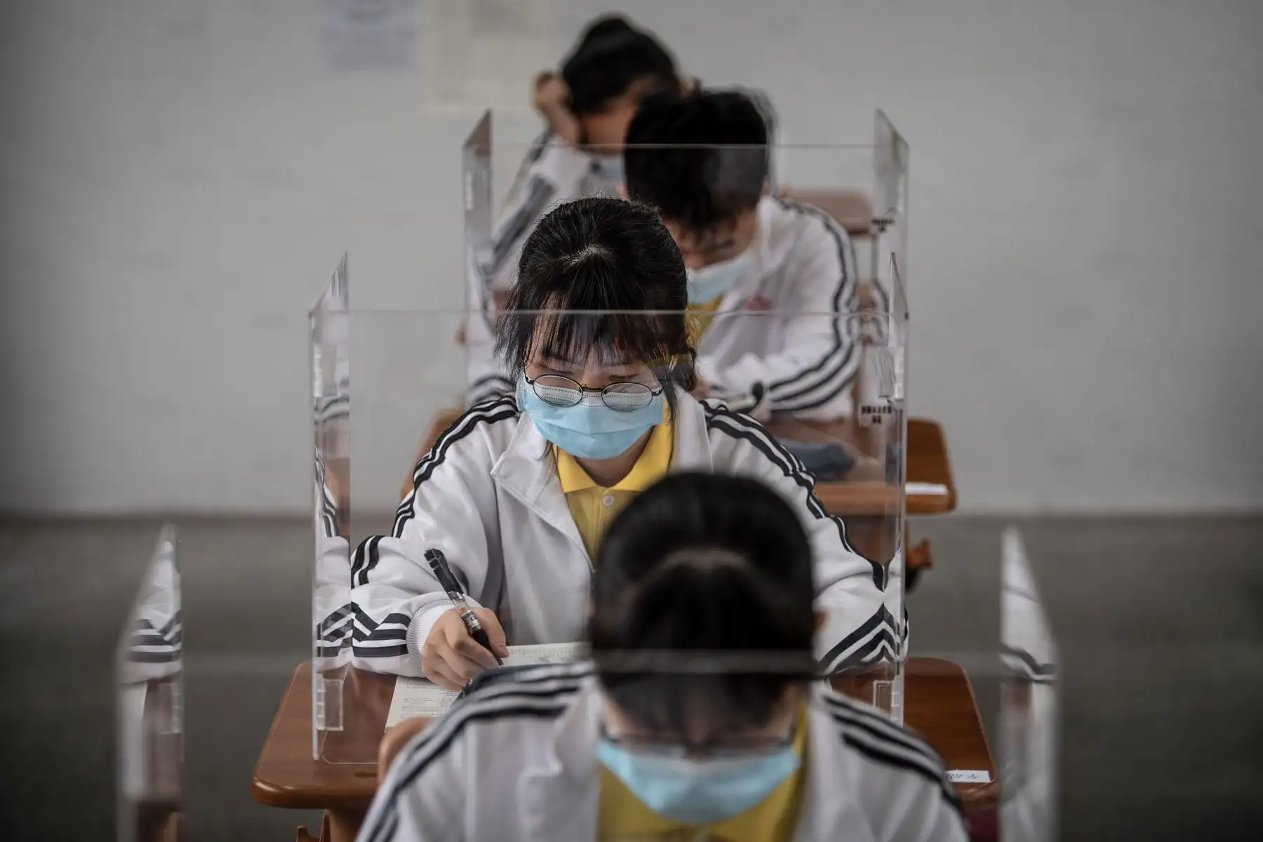 Los estudiantes de último año de secundaria estudian con separadores de plástico en un aula en Wuhan, en la provincia central china de Hubei. Foto: AFP