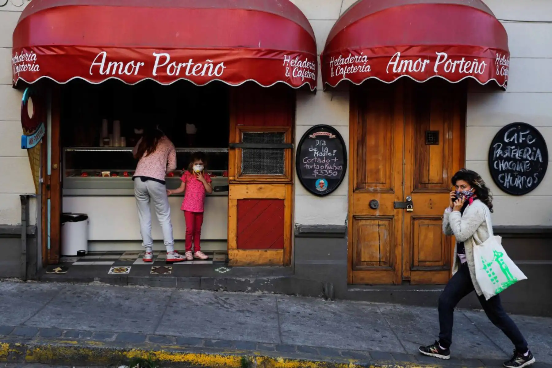 Una mujer que usa una mascarilla como medida preventiva contra el nuevo coronavirus COVID-19, camina por un helado y una cafetería en Valparaíso, Chile, el 10 de mayo de 2020.

(Foto de Pablo TOMASELLO / AFP)