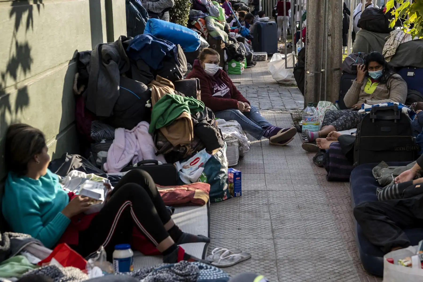 Los ciudadanos venezolanos varados permanecen fuera del consulado de Venezuela en Santiago el 11 de mayo de 2020, mientras esperan una solución después de que se cerraron las fronteras debido a la nueva pandemia de coronavirus. 

(Foto por Martin BERNETTI / AFP)