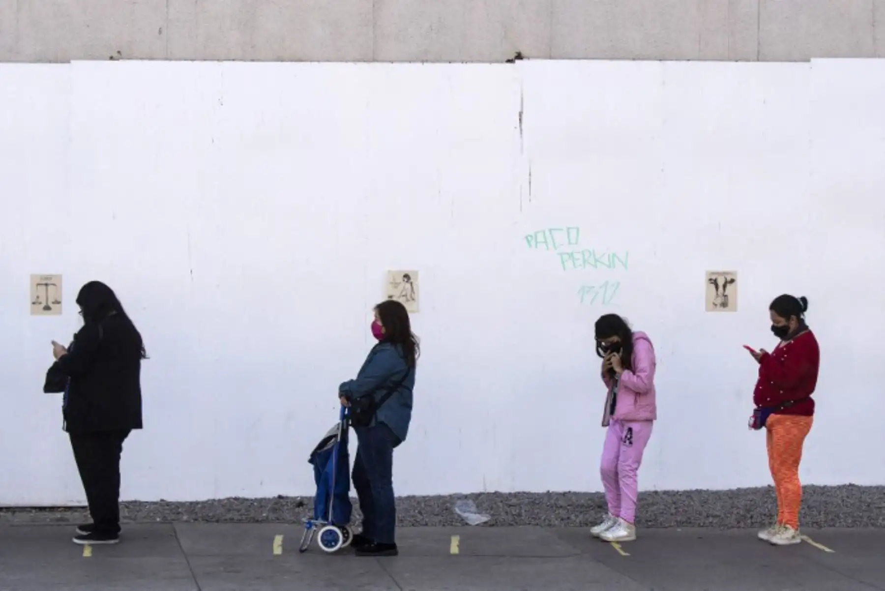 La gente mantiene la distancia de seguridad mientras hacen cola frente a un supermercado en Santiago, el 13 de mayo de 2020, dos días antes de que comience una cuarentena total en la capital chilena para ayudar a frenar la propagación del nuevo coronavirus. 

(Foto por MARTIN BERNETTI / AFP)