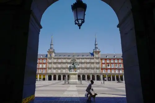 Una mujer pasea a sus perros en la Plaza Mayor de Madrid durante el cierre nacional para prevenir la propagación de la covid-19. Foto: AFP