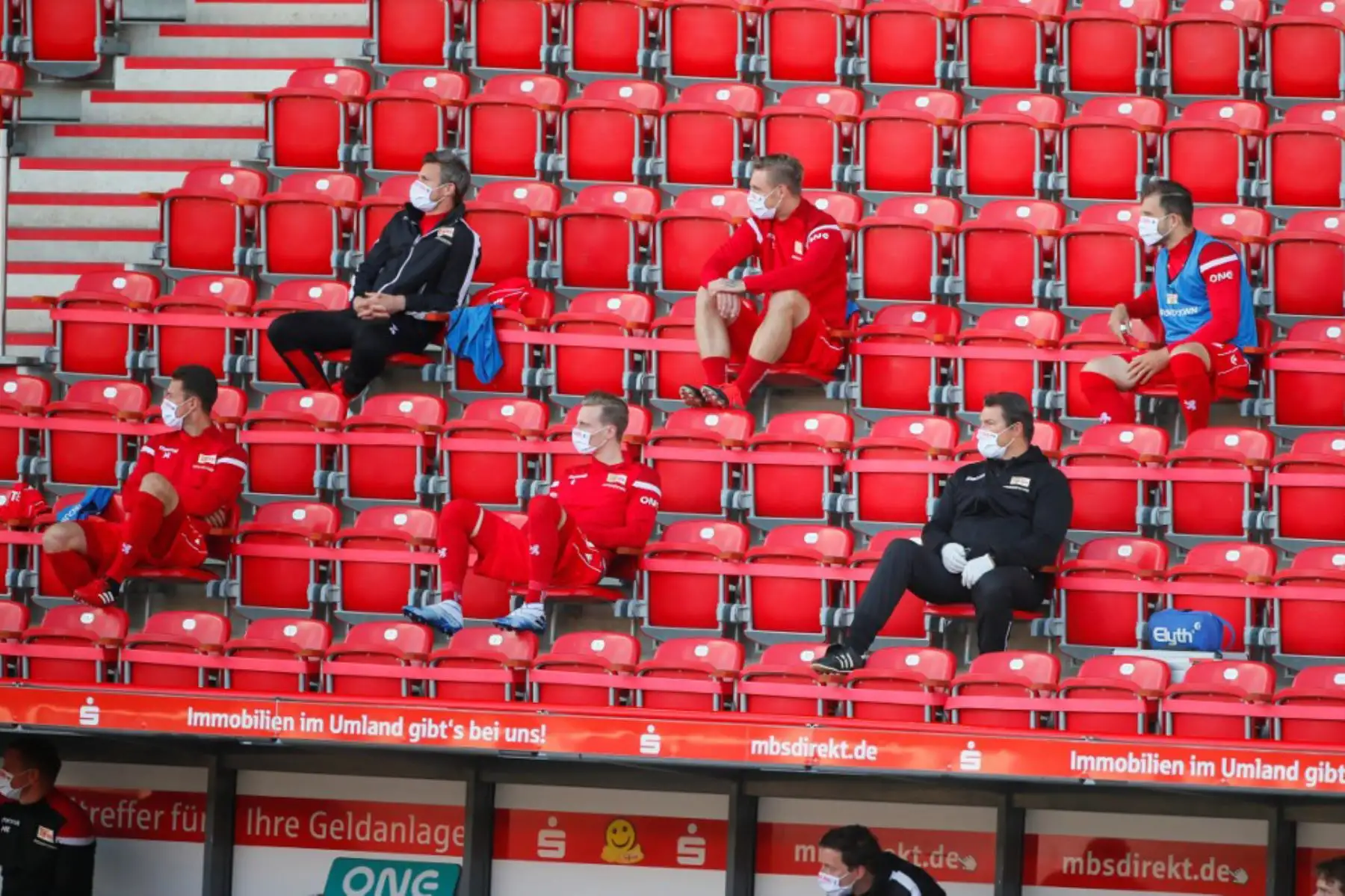 Los sustitutos del FC Union Berlin usan máscaras faciales y mantienen la distancia social en las gradas durante el partido de fútbol de la Bundesliga. Foto: AFP