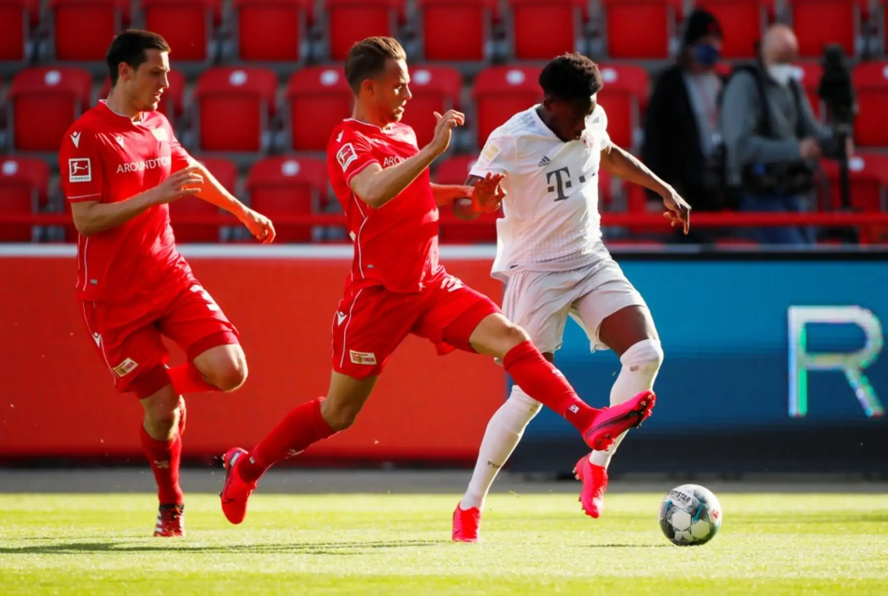 El delantero danés de Union Berlin, Marcus Ingvartsen y el centrocampista canadiense de Bayern Munich Alphonso Davies compiten por el balón durante el partido de fútbol de la Bundesliga. Foto: AFP