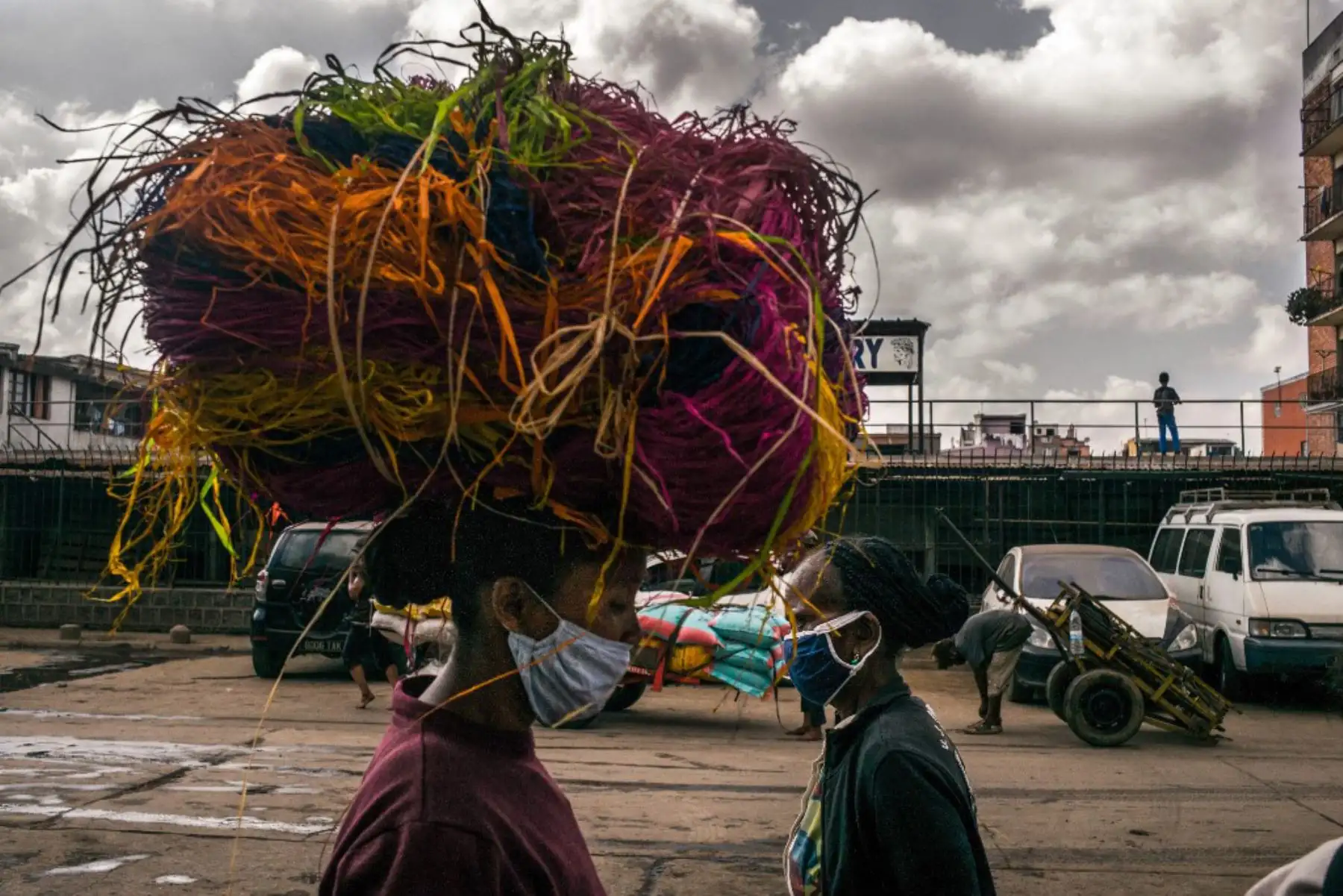 Una mujer lleva un paquete de rafia de colores a través del distrito de Isotry de la capital de Madagascar. Foto: AFP