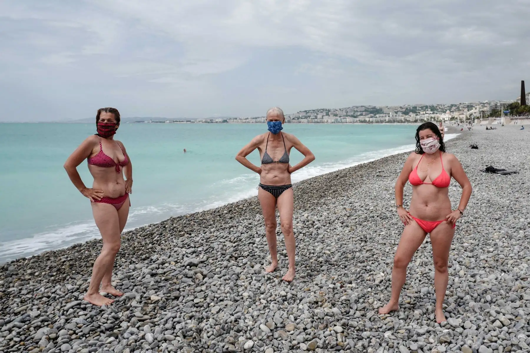Mujeres que llevan máscaras protectoras posan en la playa después de nadar durante la reapertura de algunas playas mediterráneas a lo largo de la ciudad francesa de Niza. Foto: AFP