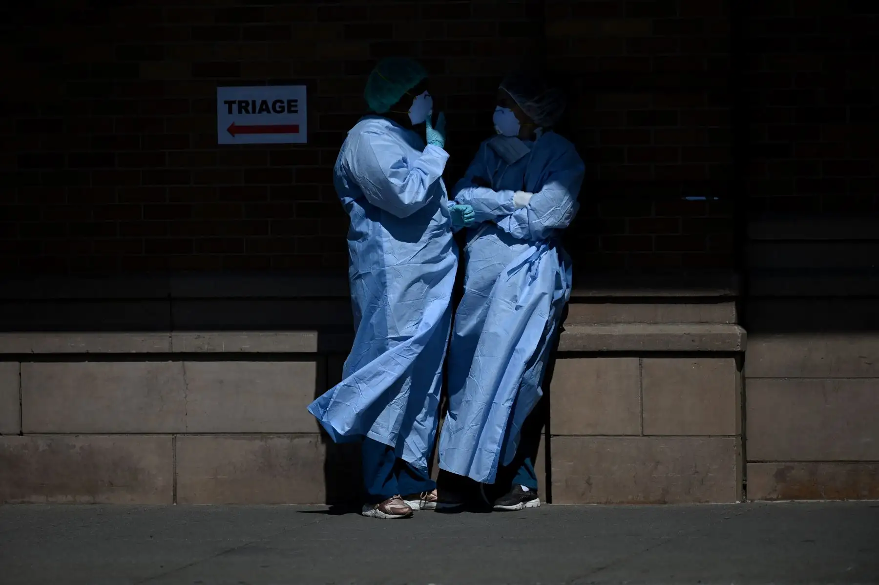Los trabajadores médicos se toman un descanso fuera del área especial de COVID-19 en el Centro Médico Maimonides. Foto: AFP