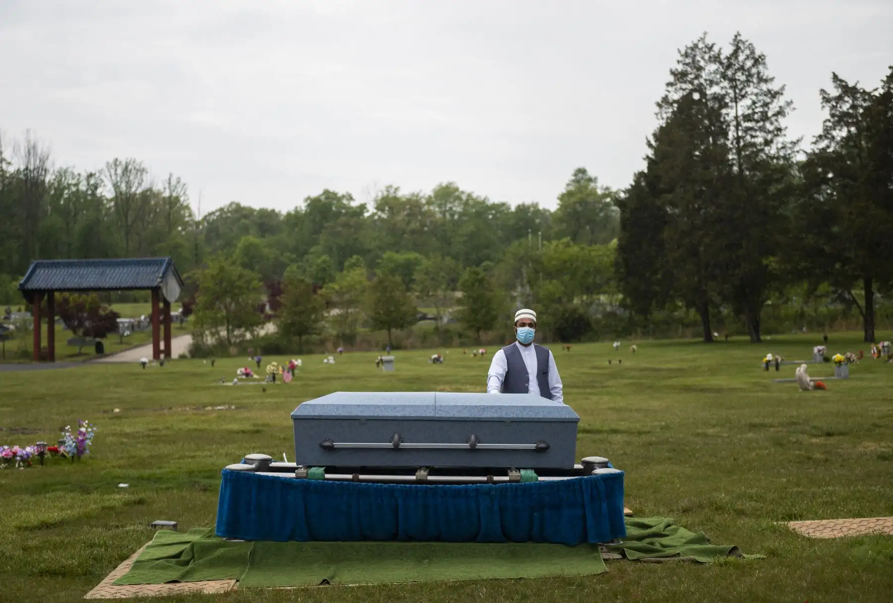 El imán Said Sherzadi está solo cerca del ataúd de Ghulam Merzazada, en el cementerio del parque National Memorial en Fairfax, Virginia. Foto: AFP