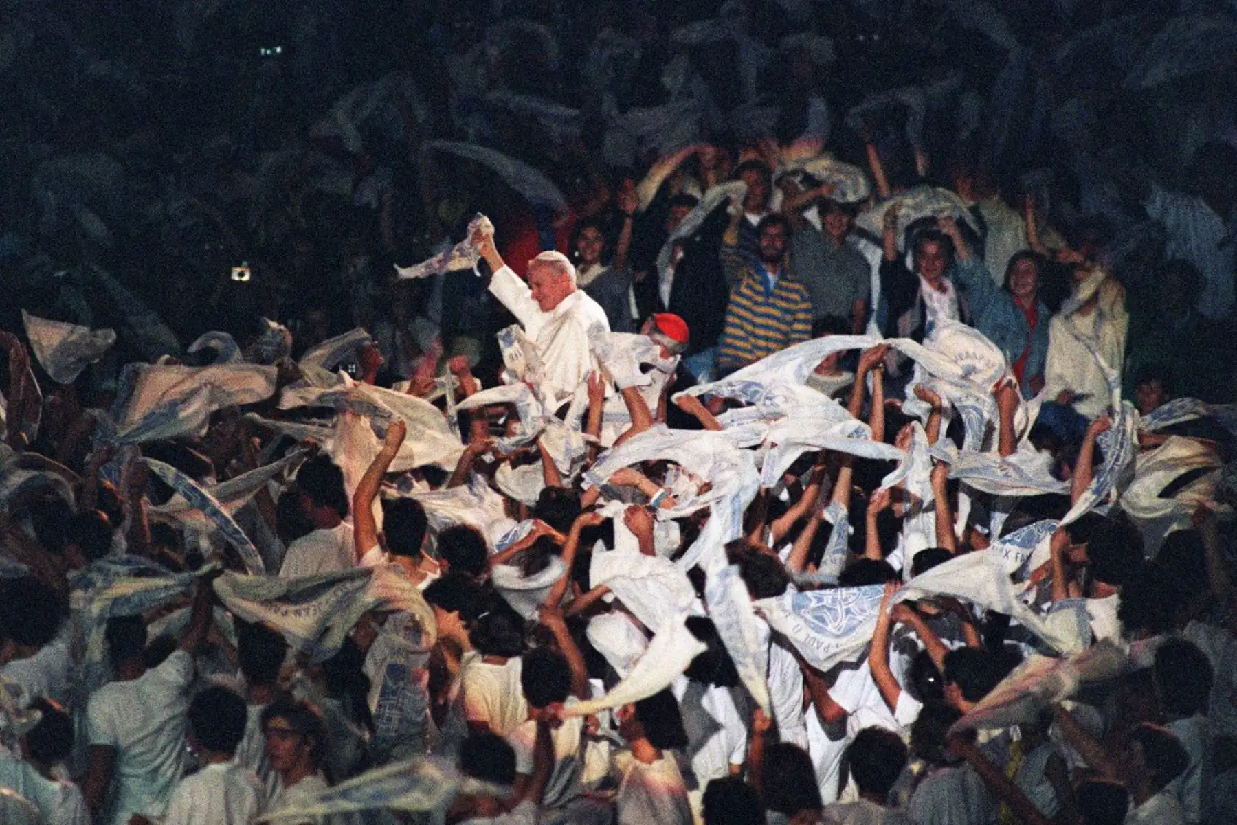 El Papa Juan Pablo II agita una bufanda cuando se encuentra con unos 50,000 jóvenes durante una reunión el 5 de octubre de 1986 en Lyon. 
Foto: AFP