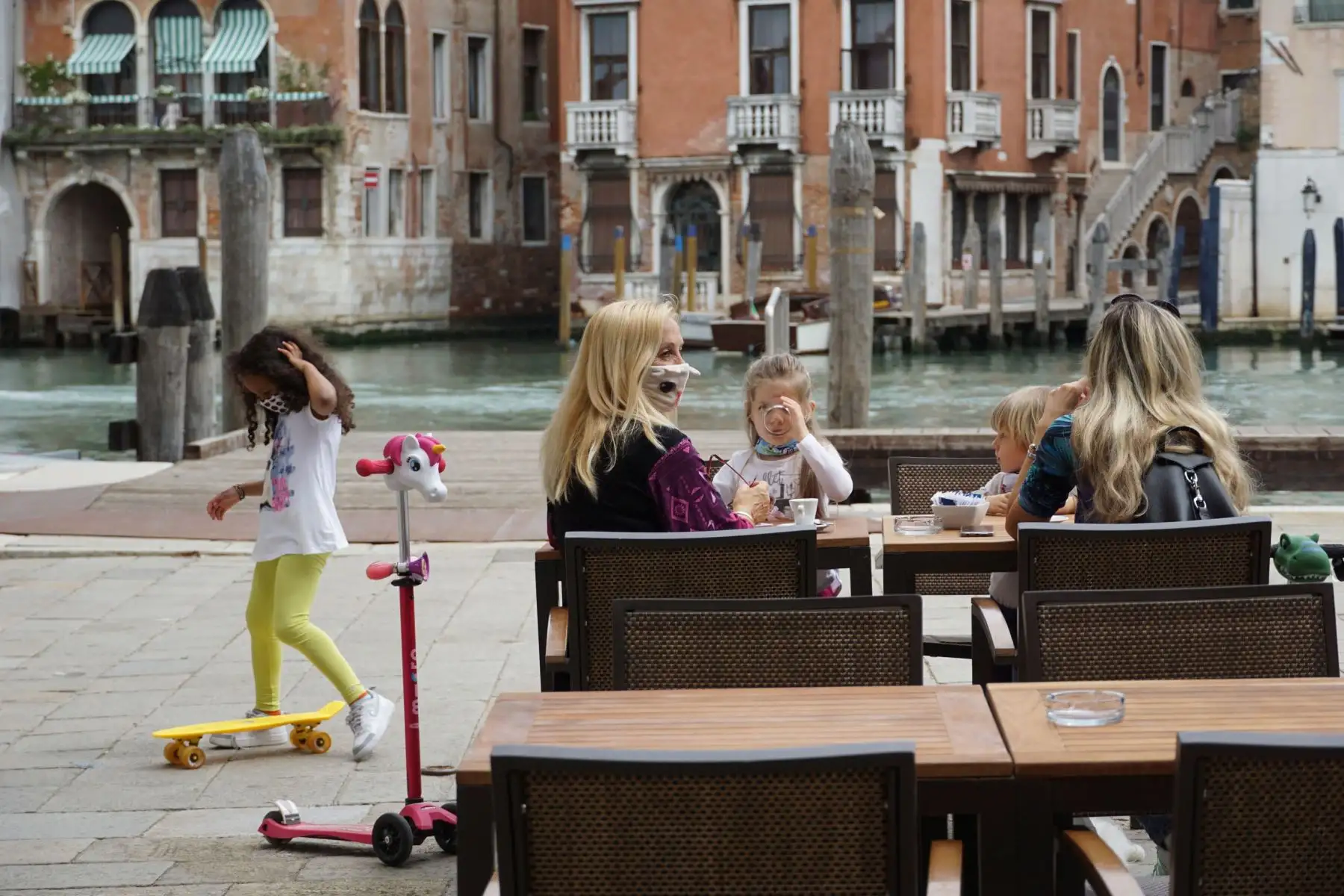 Dos jóvenes madres e hijas desayunan sentadas en una mesa de café a orillas del Herbaria en Rialto en Venecia, Italia.
Foto: EFE