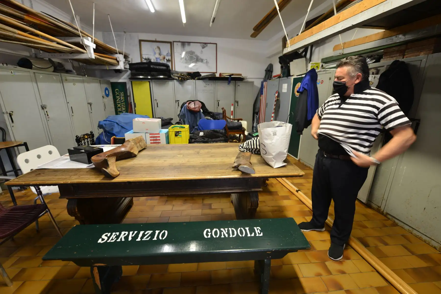 Un gondolero se pone su camiseta mientras se prepara para reanudar el servicio de góndolas en el terraplén de San Toma en Venecia. Foto: AFP