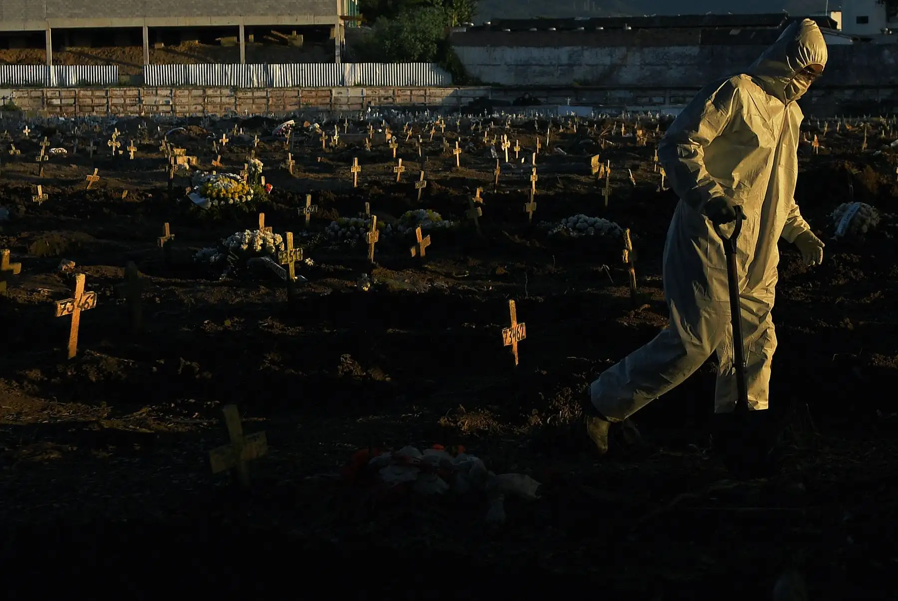 Un trabajador funerario que usa ropa protectora como medida preventiva contra el nuevo coronavirus, COVID-19, camina por el cementerio de Caju en Río de Janeiro, Brasil. Foto: AFP