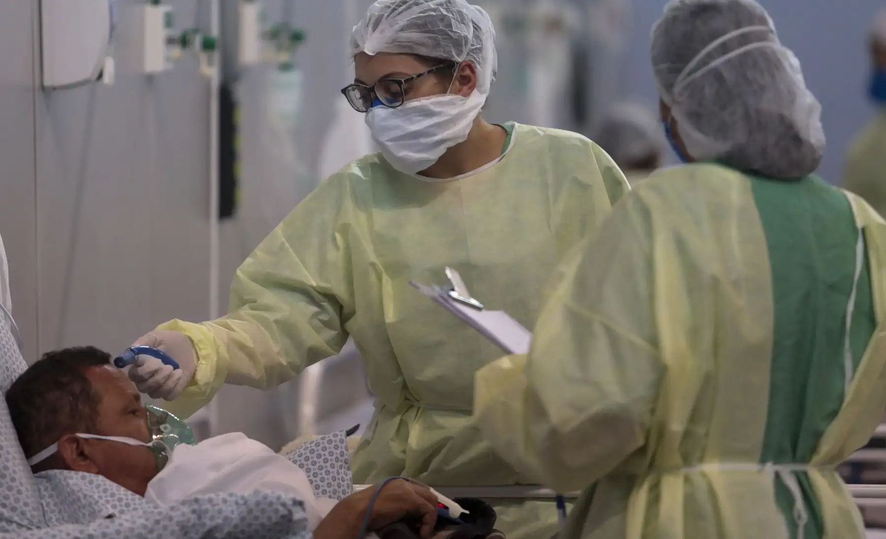 Una enfermera verifica la temperatura de un paciente afectado por el coronavirus COVID-19 en un hospital de campaña instalado en un gimnasio deportivo, en Santo Andre, estado de Sao Paulo. Foto: AFP
