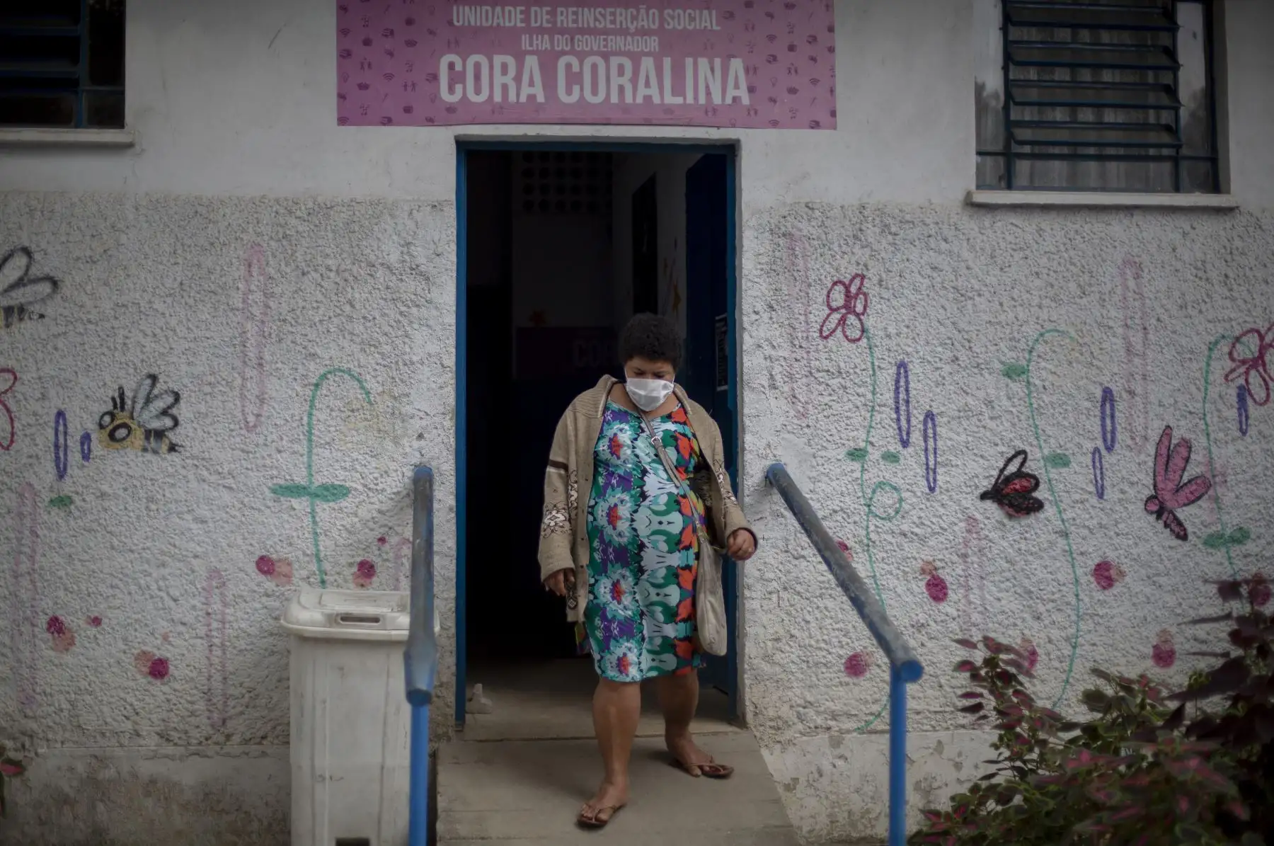Una residente del refugio público Stella Maris sale de un dormitorio mientras los soldados de las Fuerzas Armadas de Brasil desinfectan el lugar en el barrio de Ilha do Governador en Río de Janeiro. Foto: AFP