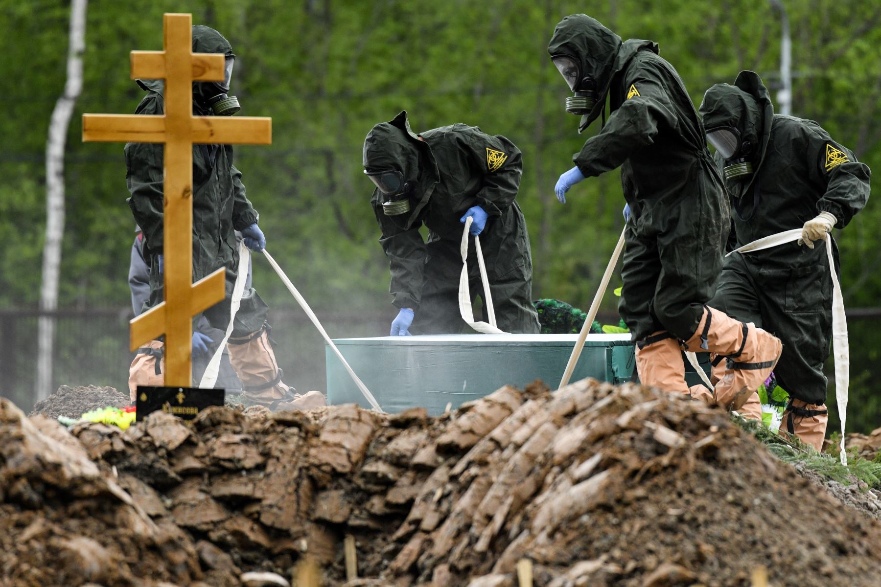 Los trabajadores del cementerio que usan equipo de protección entierran a una víctima de coronavirus en un cementerio en las afueras de Moscú. Foto: AFP