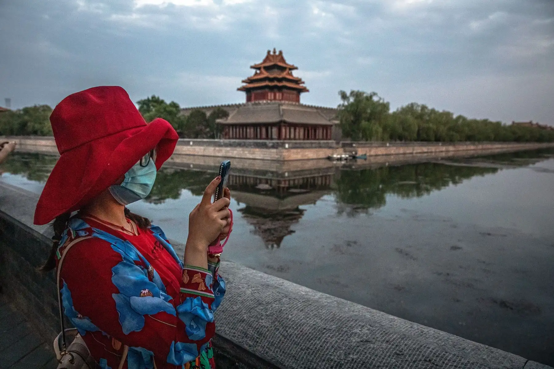 Una mujer con una máscara protectora se encuentra cerca de la Ciudad Prohibida, en Beijing, China. Foto: EFE