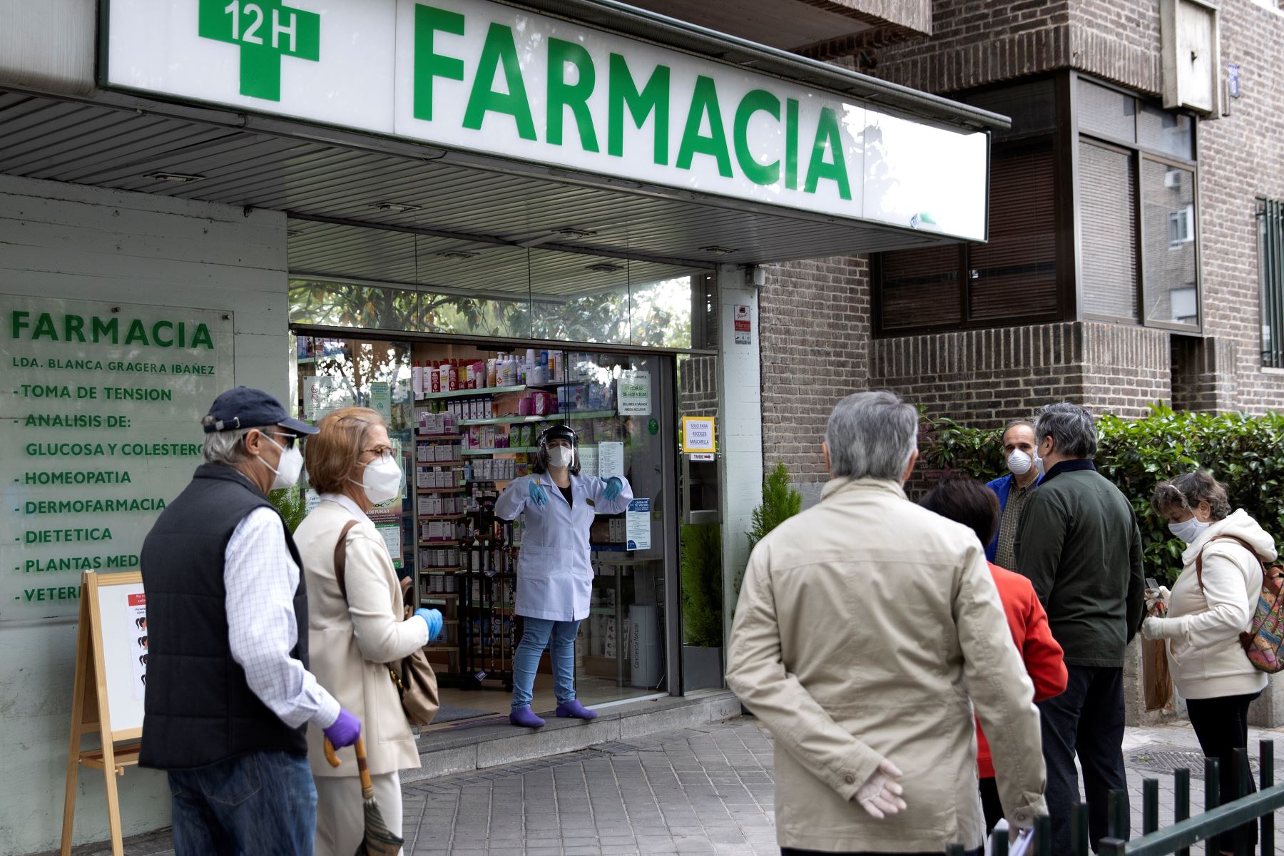 Varias personas hacen cola para recoger sus mascarillas en una farmacia de Madrid luego que se decretara su uso obligatorio. Foto: EFE