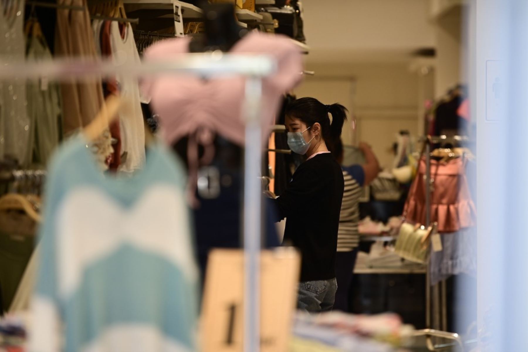 Una mujer que llevaba una máscara facial hace compras en Madrid , ya que el uso de máscaras se hizo obligatorio en público donde no es posible el distanciamiento social. 
Foto: AFP