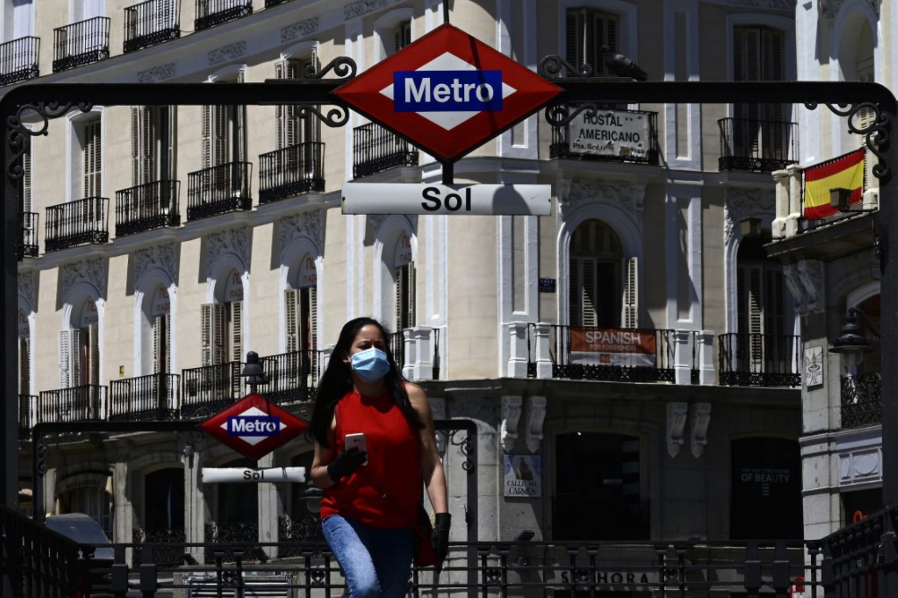 Una mujer que llevaba una máscara sale de la estación de metro Sol, ya que el uso de máscaras se hizo obligatorio en público donde no es posible el distanciamiento social.
Foto: AFP