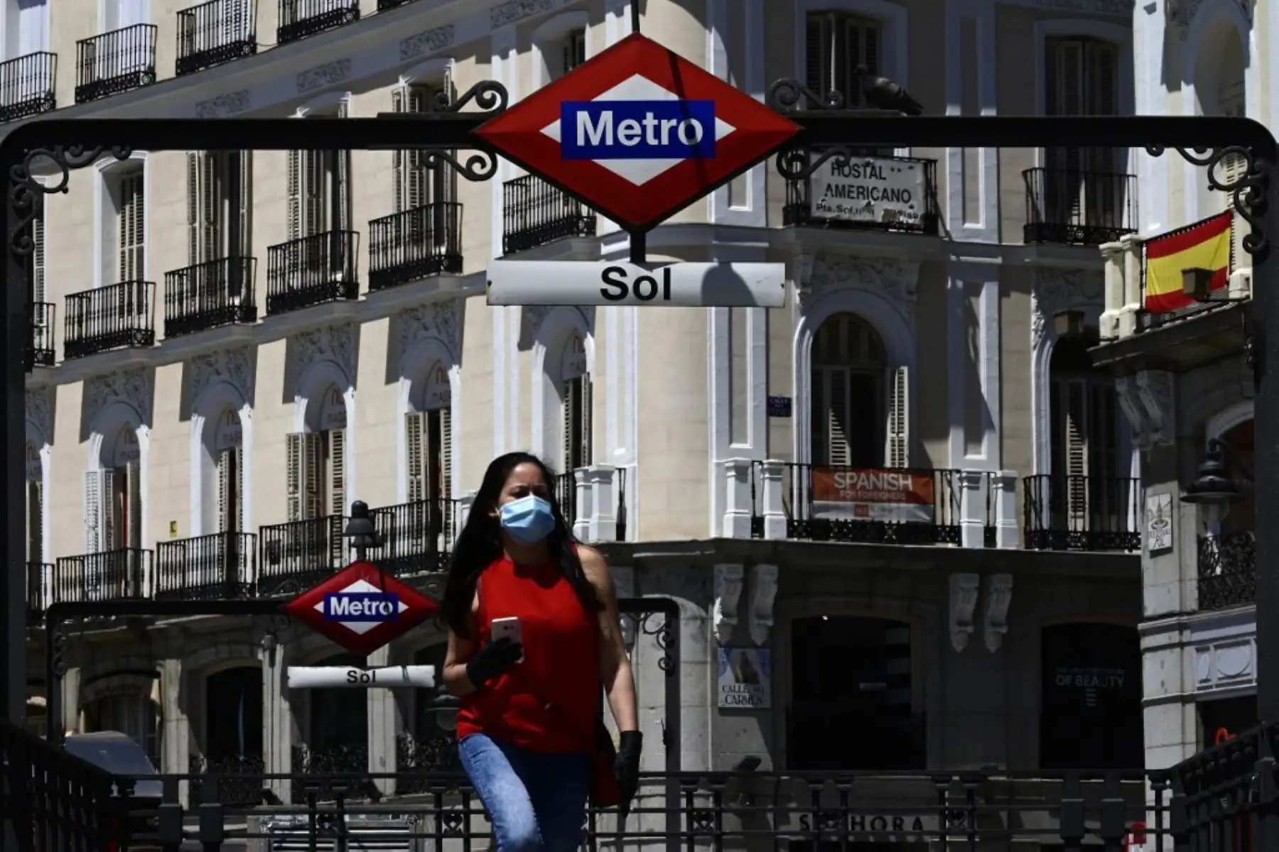 Una mujer que llevaba una máscara sale de la estación de metro Sol, ya que el uso de máscaras se hizo obligatorio en público donde no es posible el distanciamiento social.
Foto: AFP