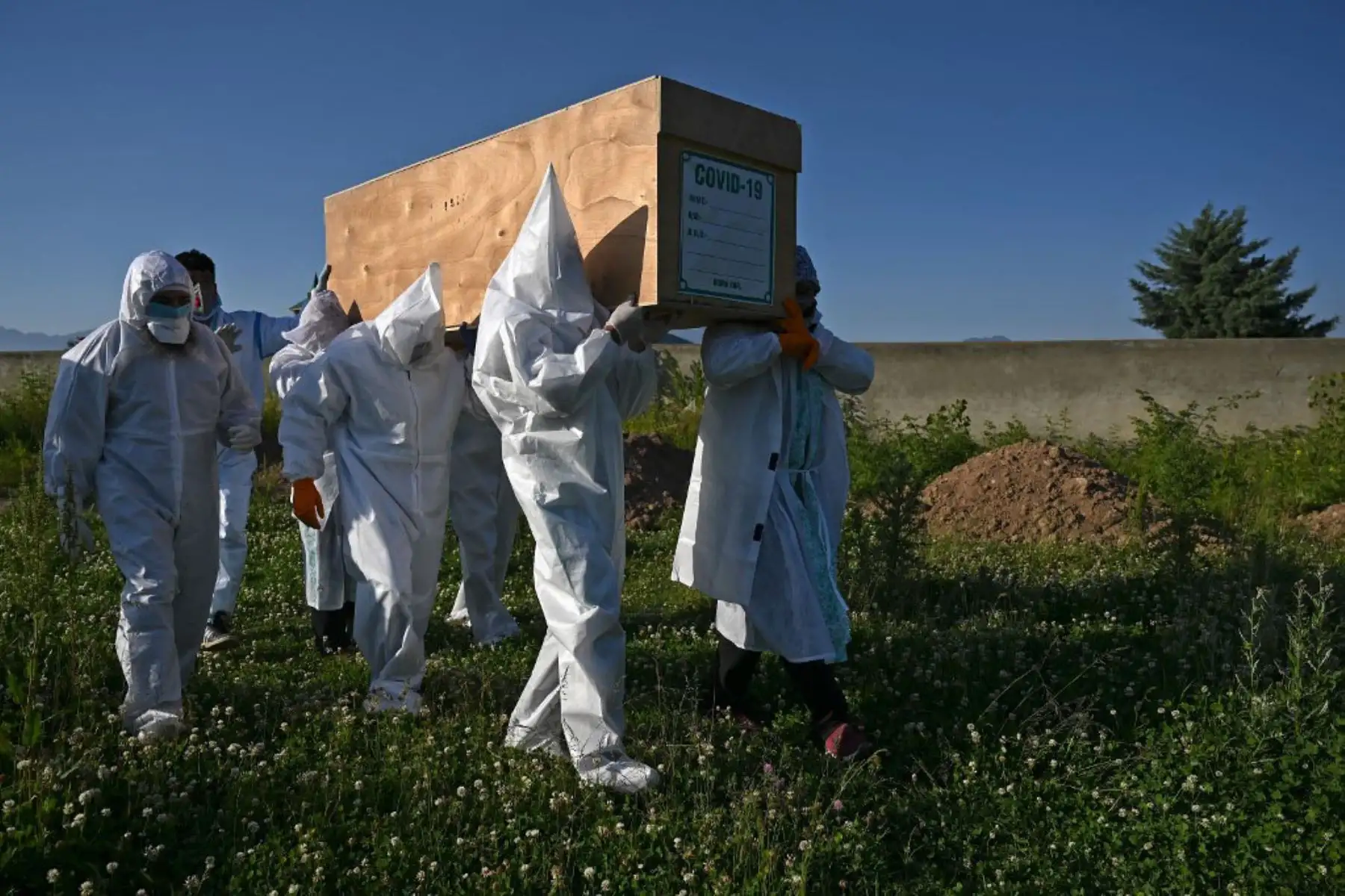 Los familiares que usan equipo de protección personal (PPE) llevan el ataúd de una mujer, que murió por el coronavirus, antes de su entierro en un cementerio en Srinagar.
Foto: AFP
