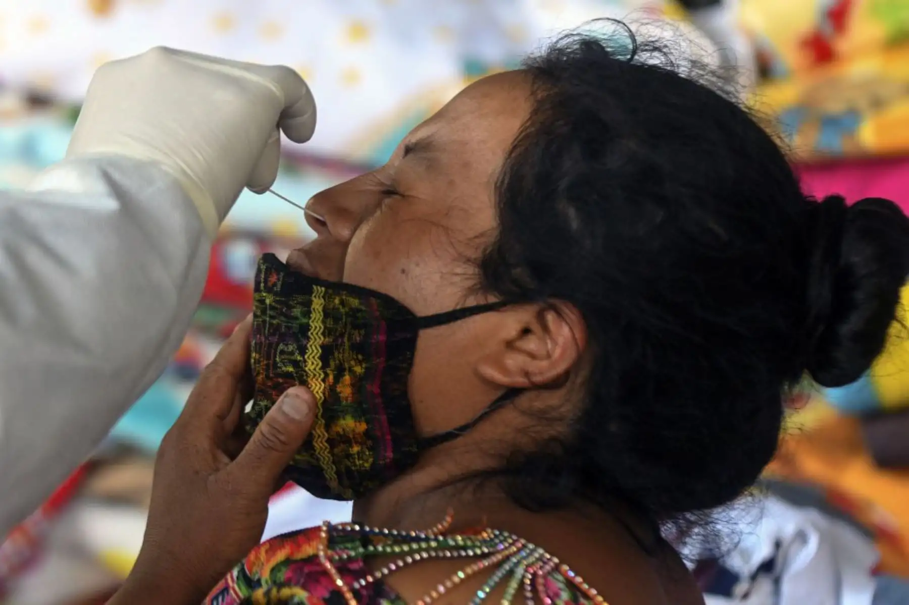 Un trabajador de la salud toma muestras de un vendedor de un puesto para evaluar si tiene  coronavirus.
Foto: AFP