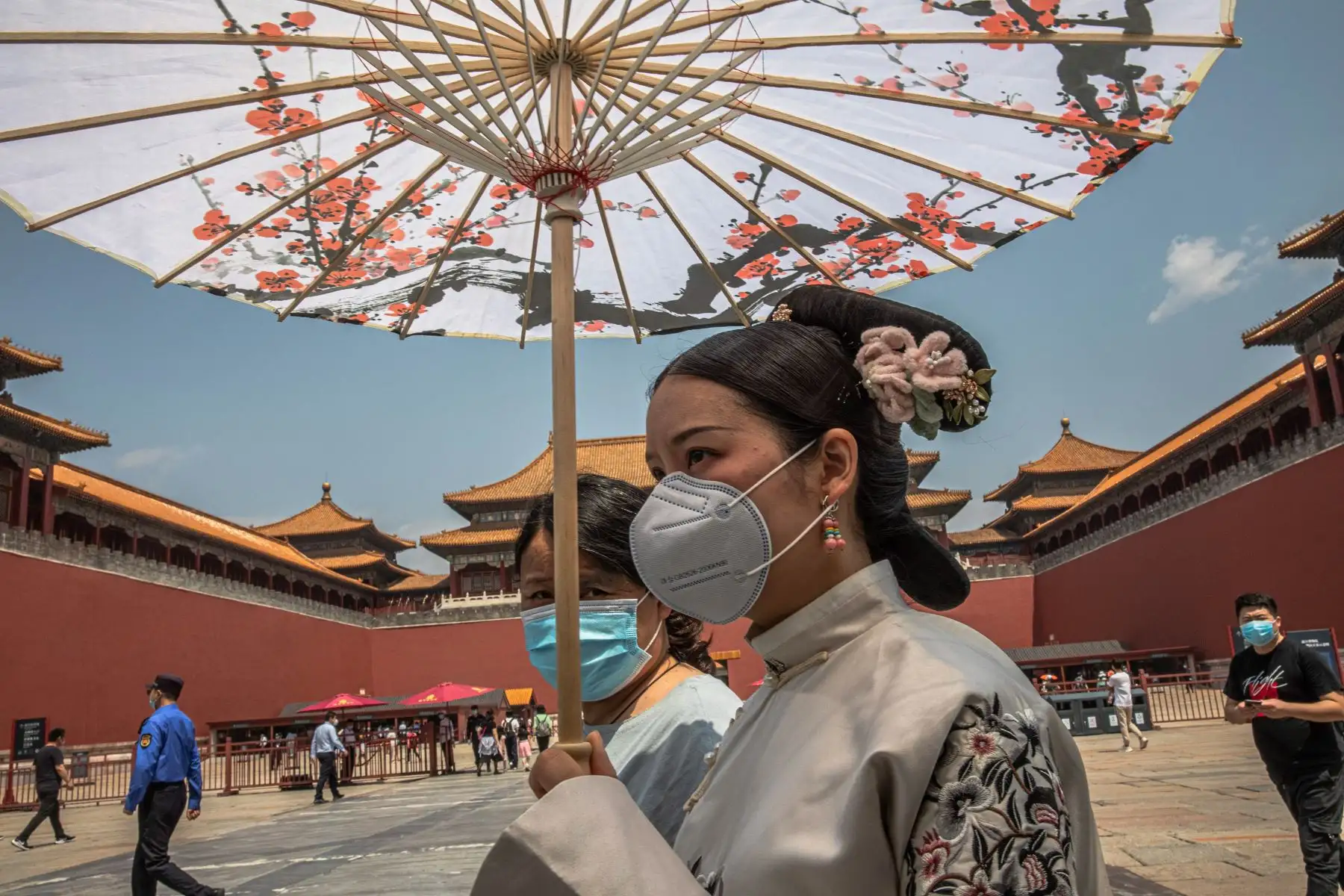 os mujeres con mascarillas caminan por la entrada de la Ciudad Prohibida el primer día del Congreso Nacional del Pueblo (APN) de China en Beijing. Foto: EFE