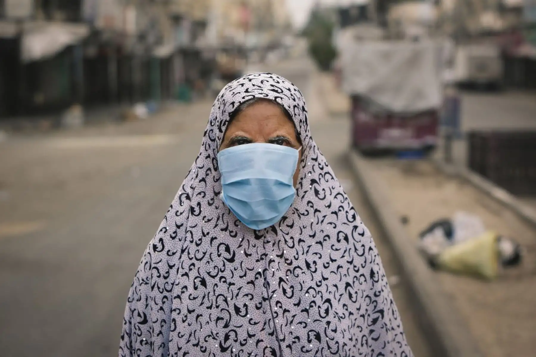 Una mujer palestina vestida con una máscara debido a la pandemia del coronavirus camina por una calle en la ciudad de Gaza. Foto: AFP