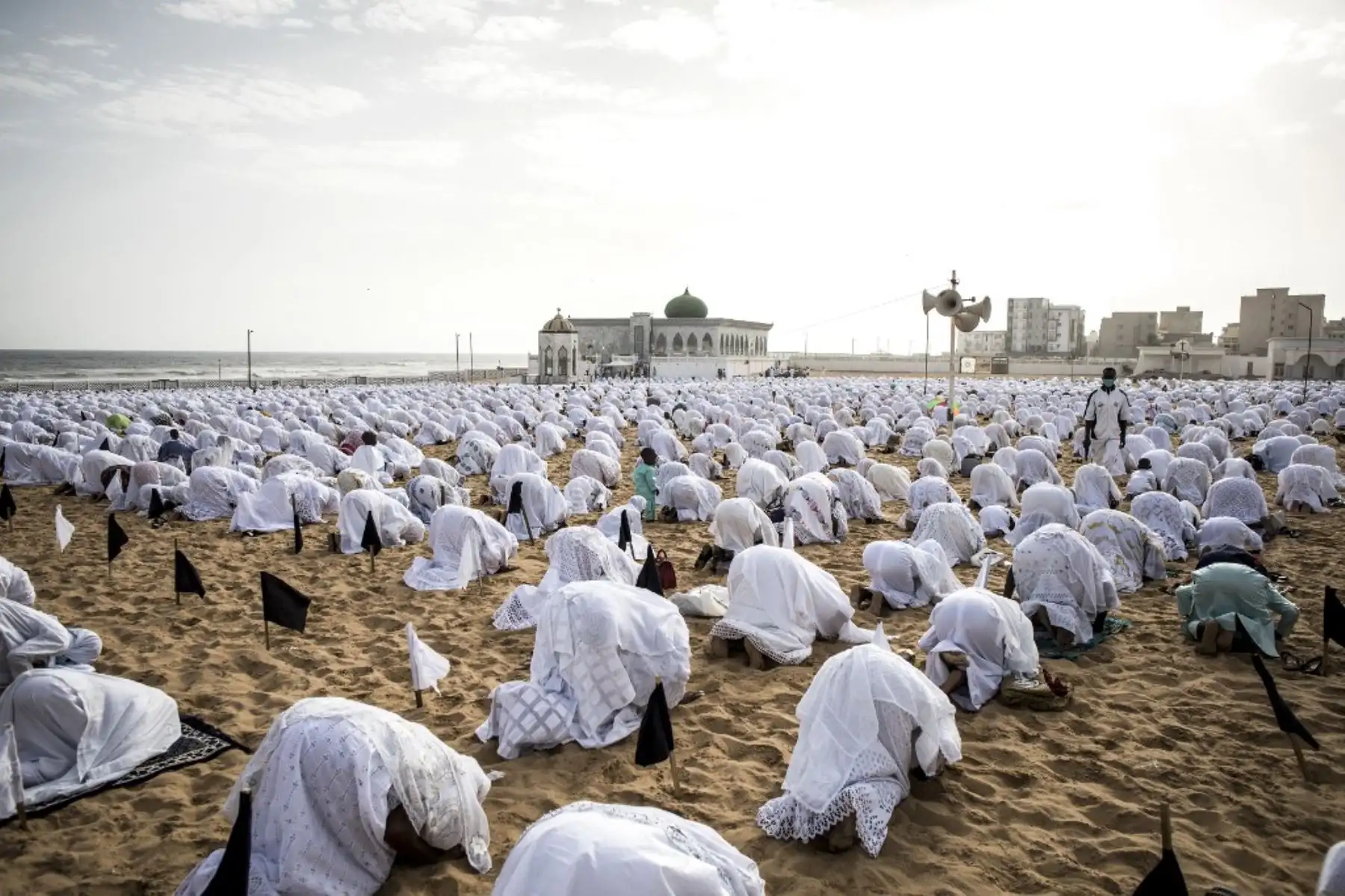 Los seguidores de la comunidad Layene con máscaras protectoras rezan en la playa frente a la Mezquita Yoff Layene, durante la festividad islámica de Korite en Dakar, Senegal. Foto: AFP