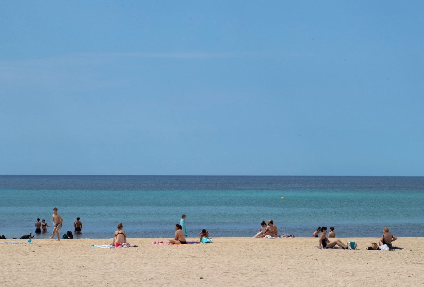 La gente toma el sol en la playa de Palma en Palma de Mallorca el 25 de mayo de 2020, el primer día después de que las playas reabrieron en algunas partes del país después de cierres de meses. Foto: AFP