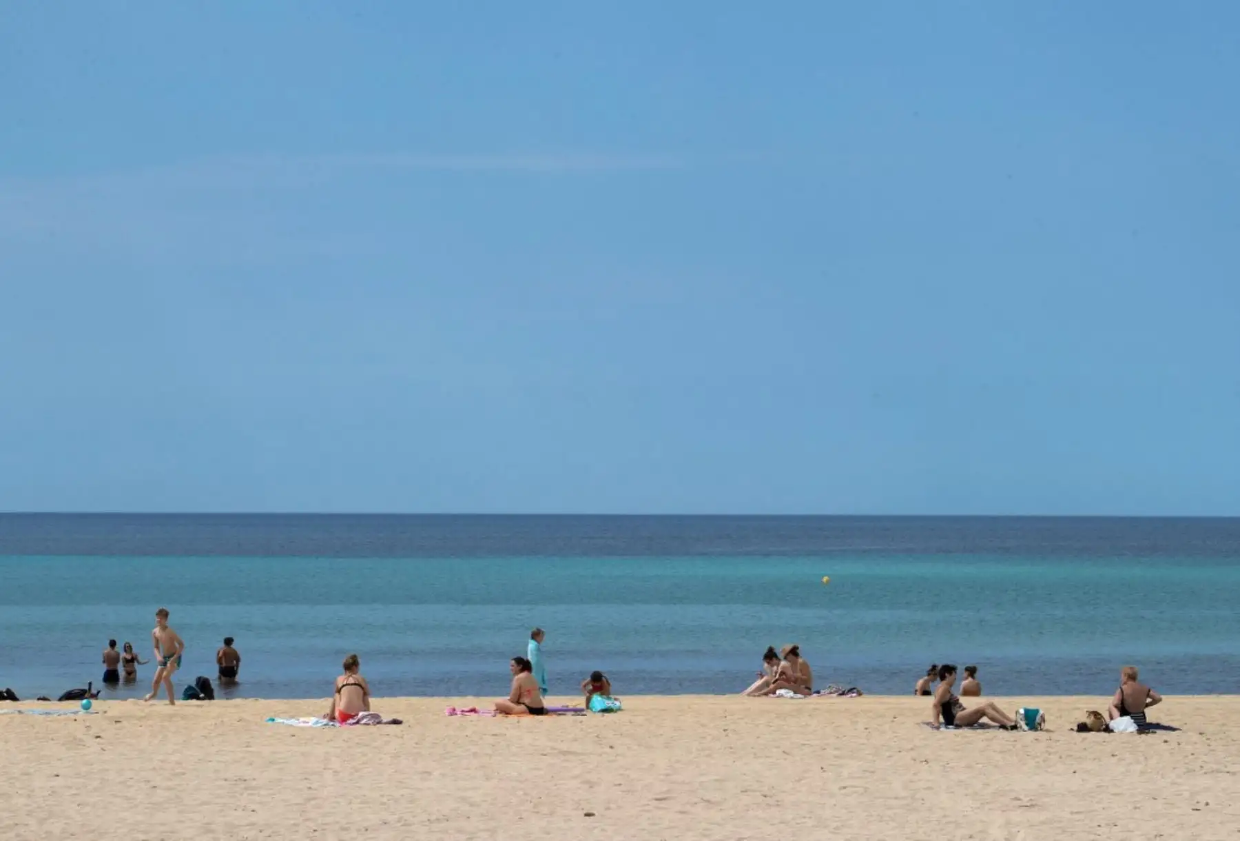 La gente toma el sol en la playa de Palma en Palma de Mallorca el 25 de mayo de 2020, el primer día después de que las playas reabrieron en algunas partes del país después de cierres de meses. Foto: AFP