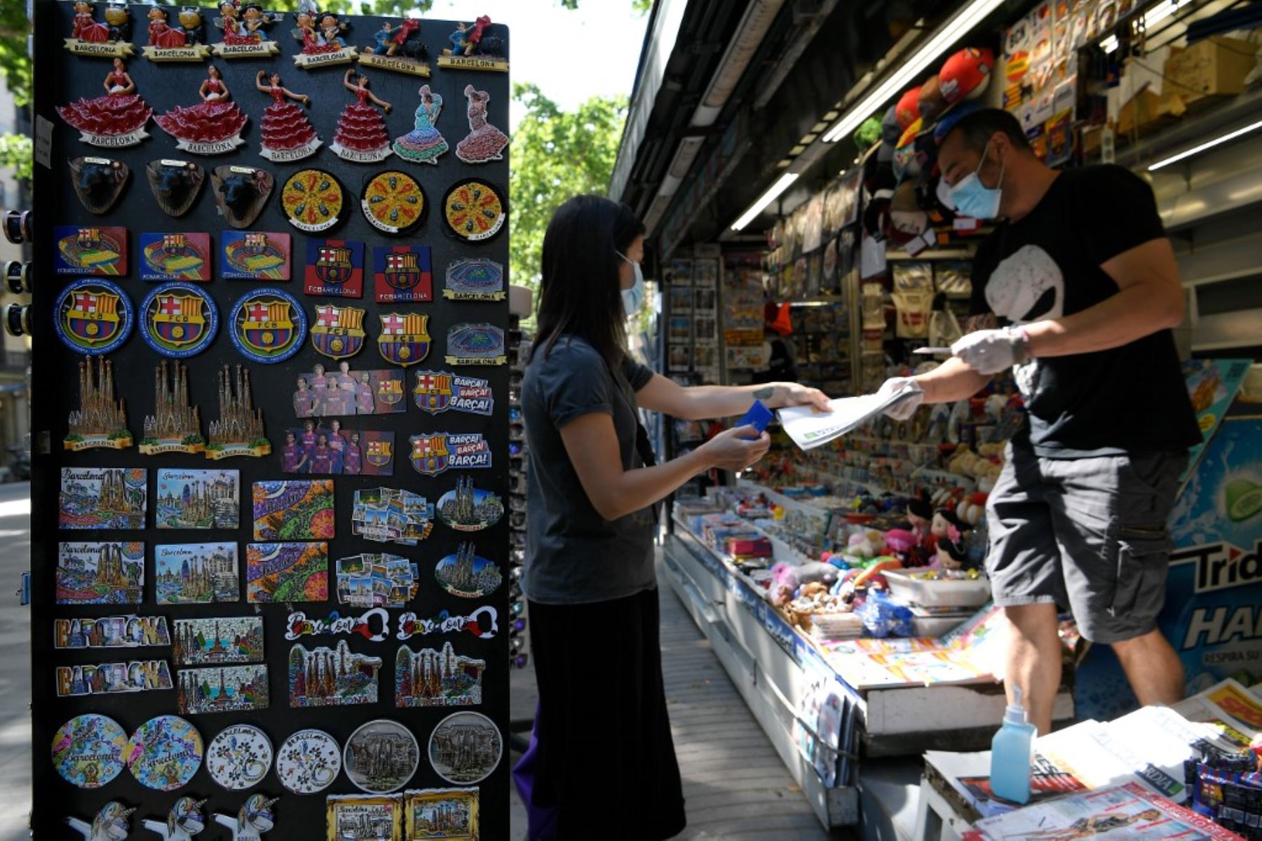 Una mujer compra un periódico en un quiosco en Barcelona. Foto: AFP