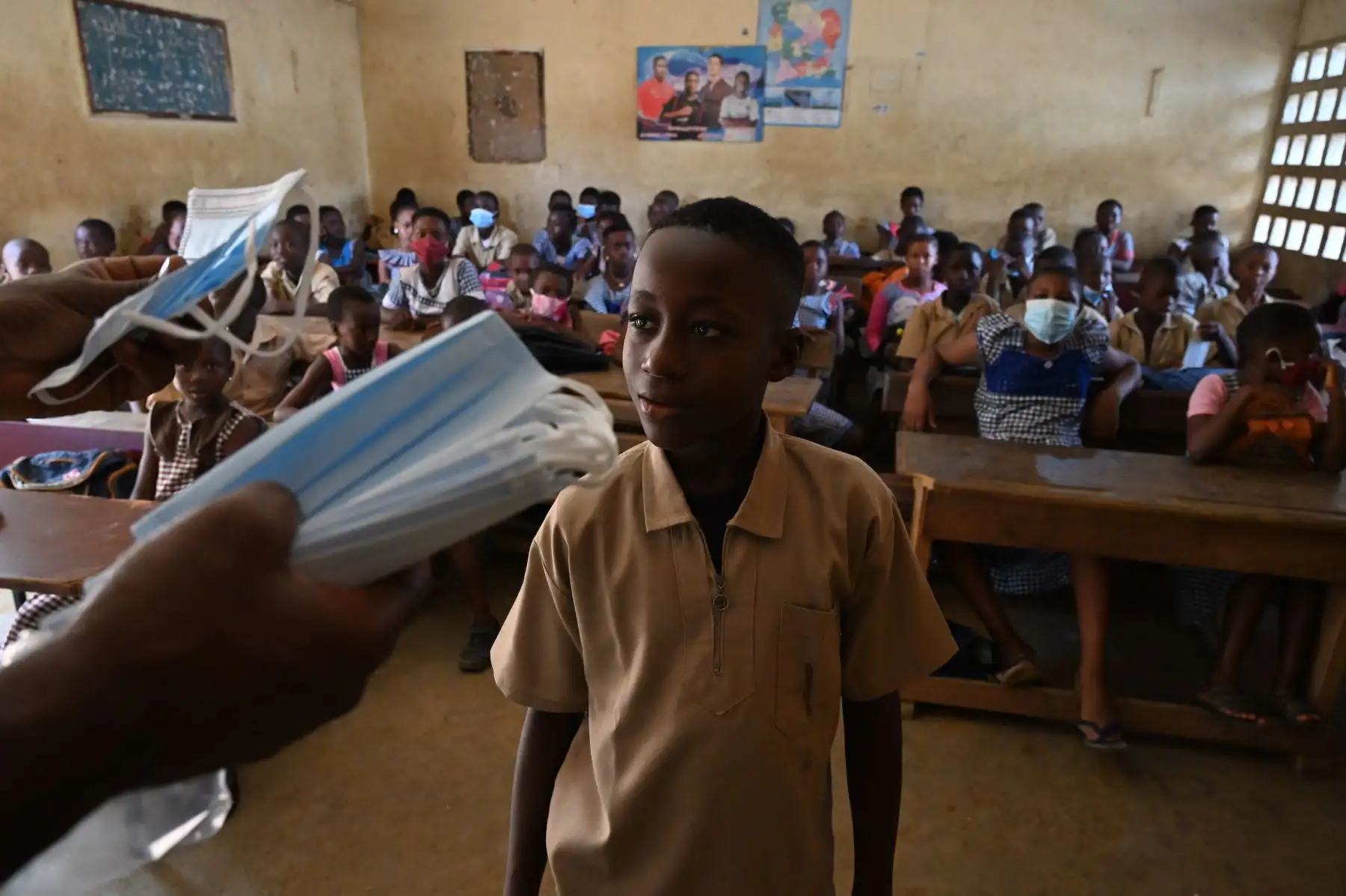 Los escolares reciben máscaras faciales en el aula del director de una escuela primaria en el popular distrito de Attecoube en Abidjan. Foto: AFP