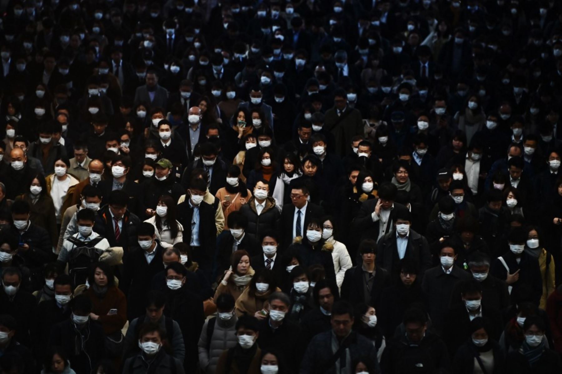 Los pasajeros vestidos de máscaras se dirigen al trabajo durante la hora pico de la mañana en la estación de tren de Shinagawa en Tokio. Foto: AFP